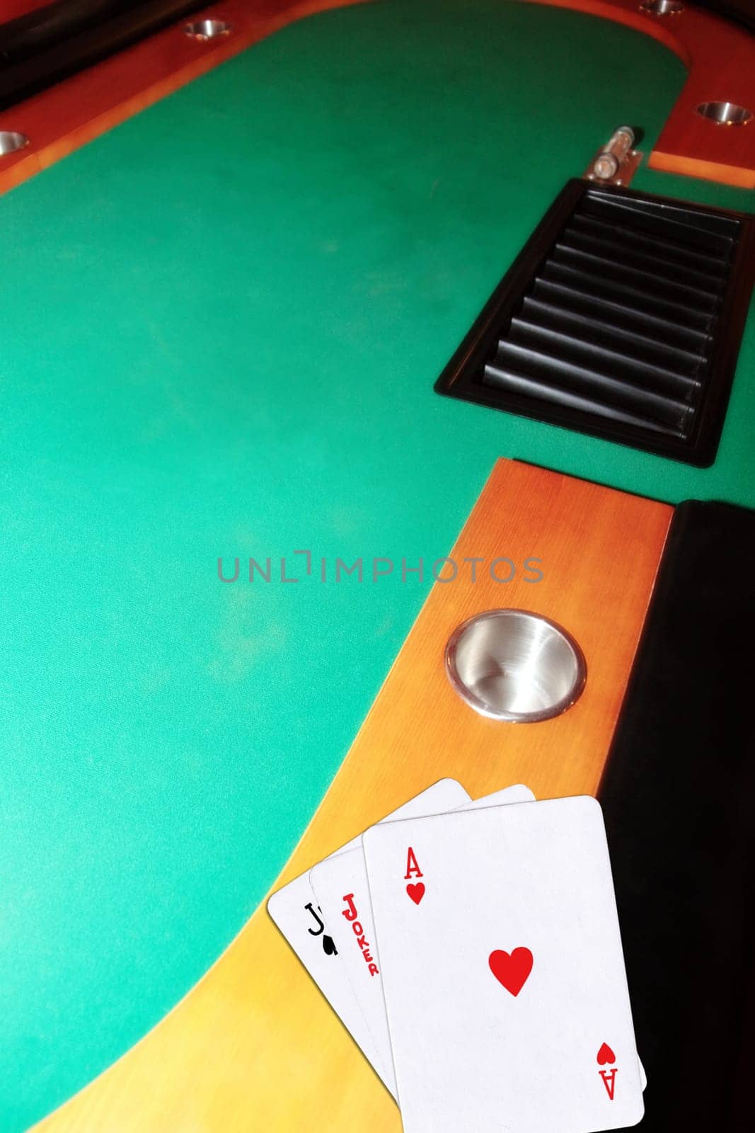 green casino table with copy space and the jack of spades joker and ace of hearts representing a blackjack game