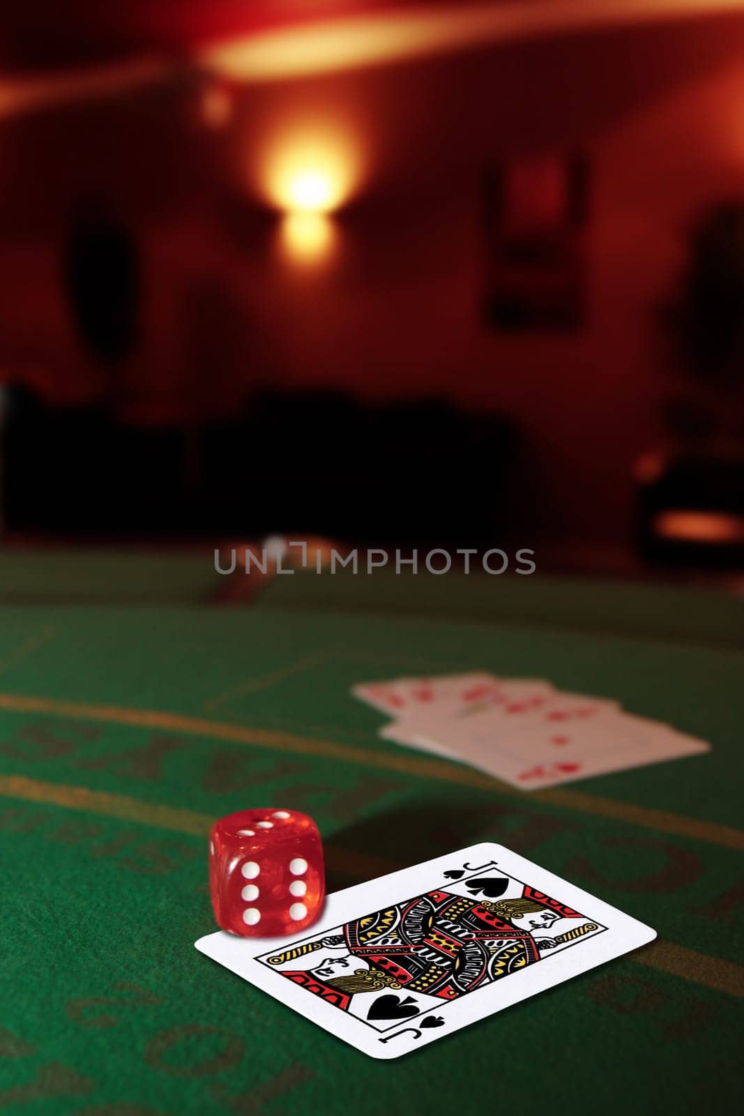 green casino table with dice on a jack of spades and a royal flush