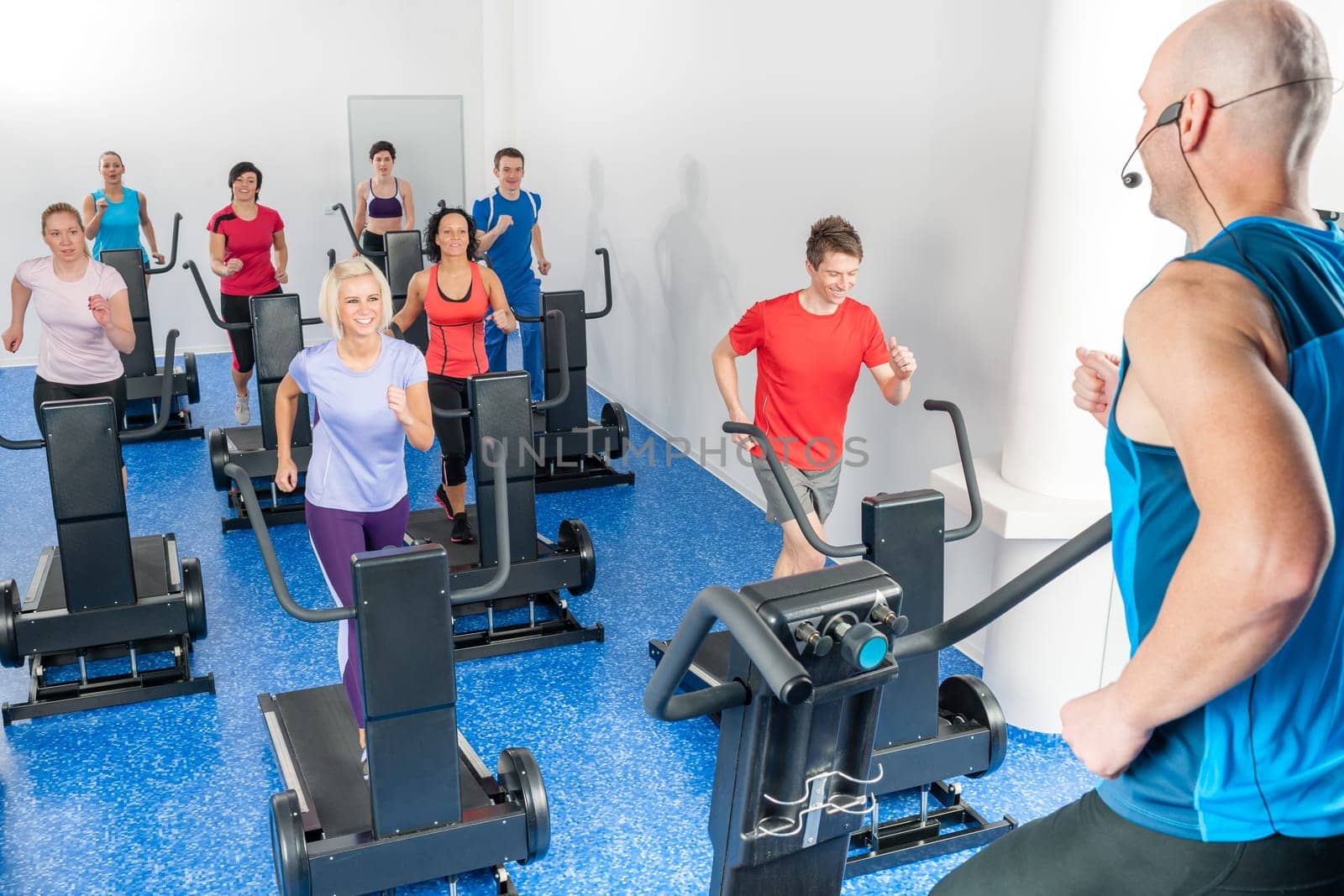 Alpinning class of young adults with fitness personal trainer
