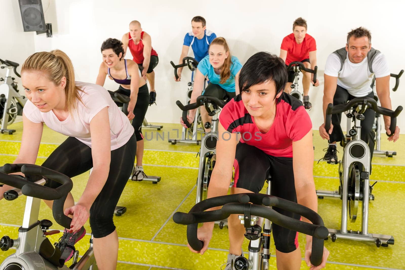 Spinning class people at the gym enjoy physical workout