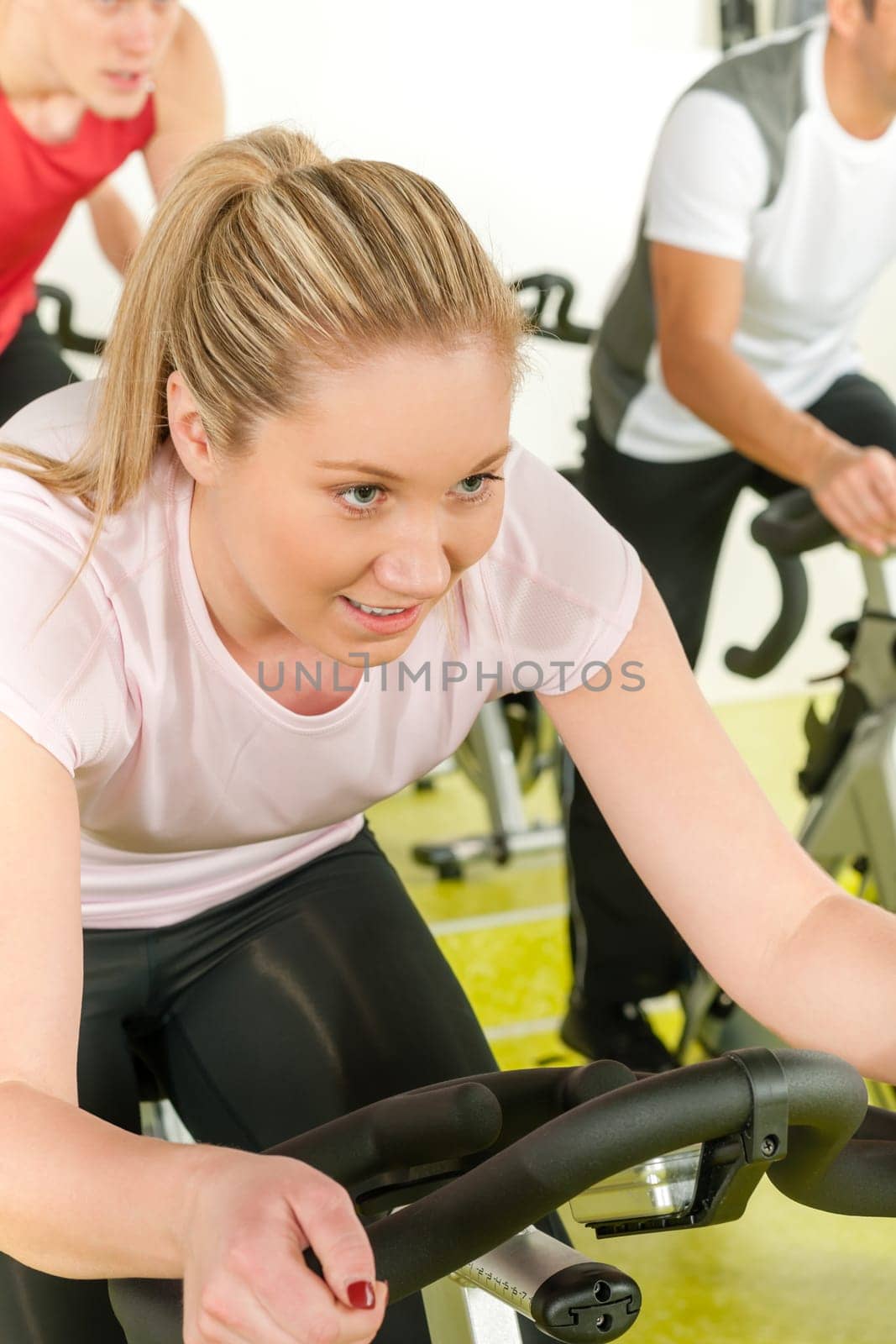 Young woman at bike spinning class enjoy cardio training