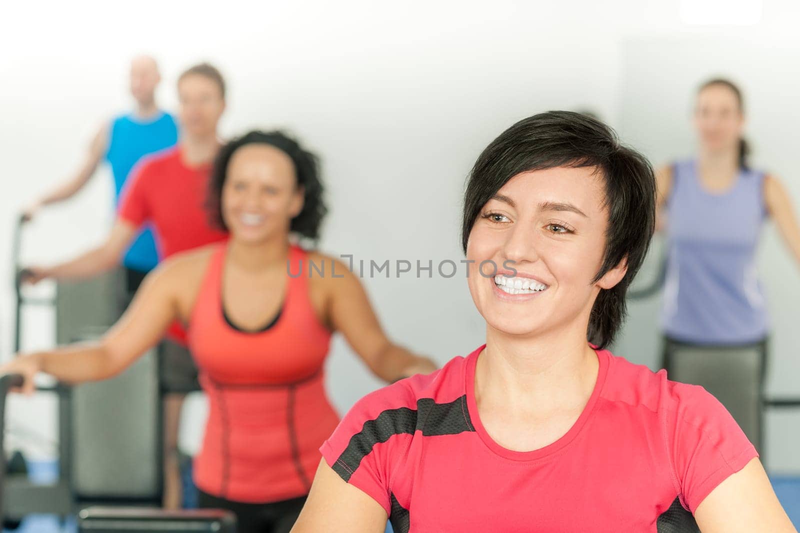 Smiling woman at fitness class gym workout on treadmill