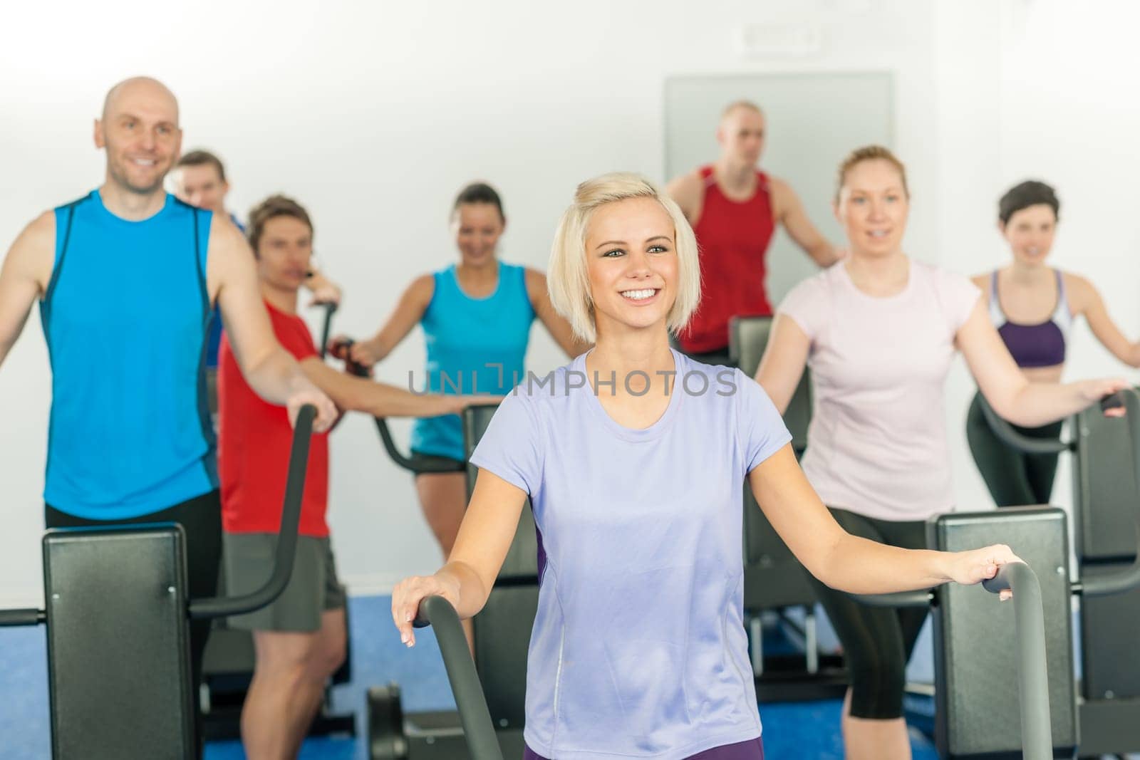 Fitness young group on treadmill running trainer at health gym