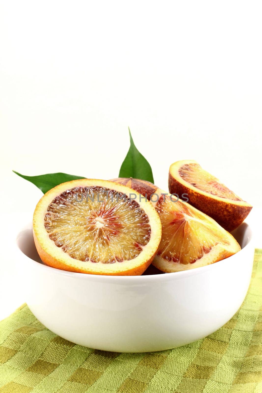 a fresh sliced blood orange against a white background