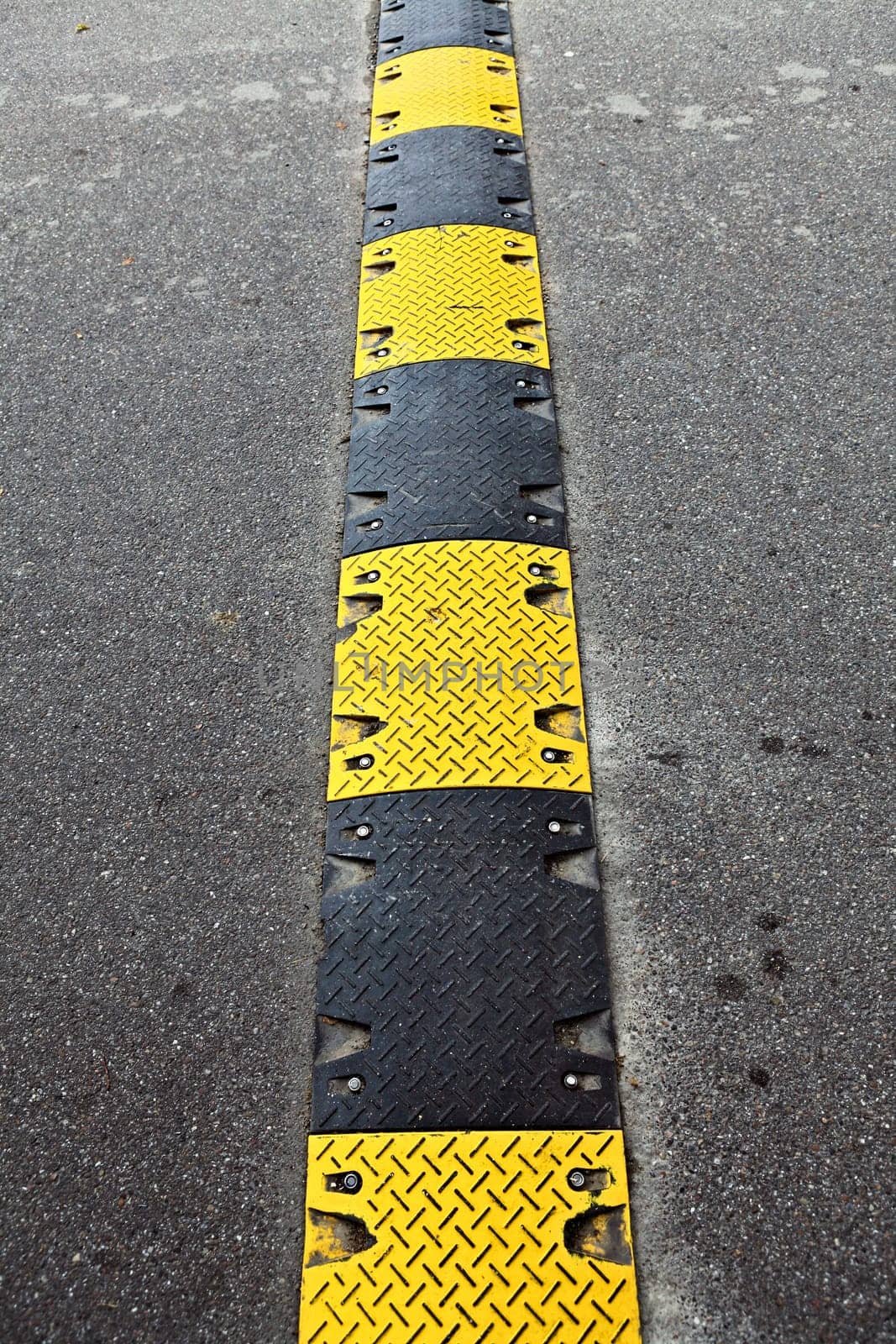 Yellow and black speed bump in a parking lot