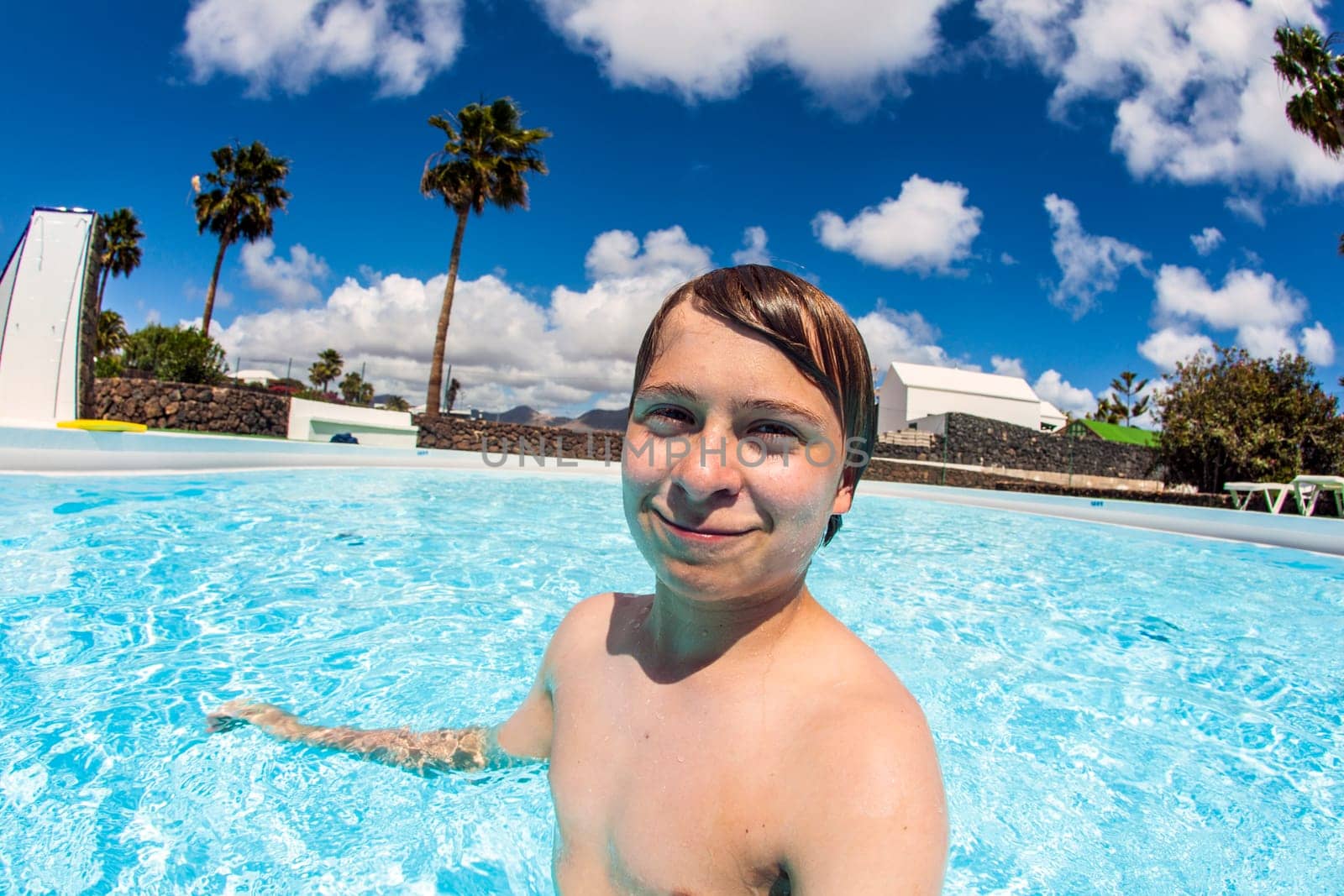 cute boy swimming in the blue pool