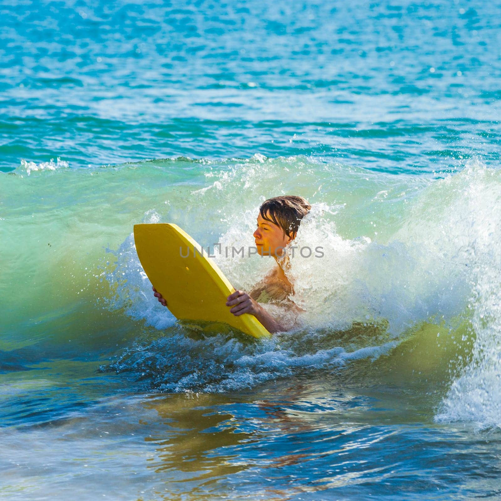 boy has fun surfing in the waves