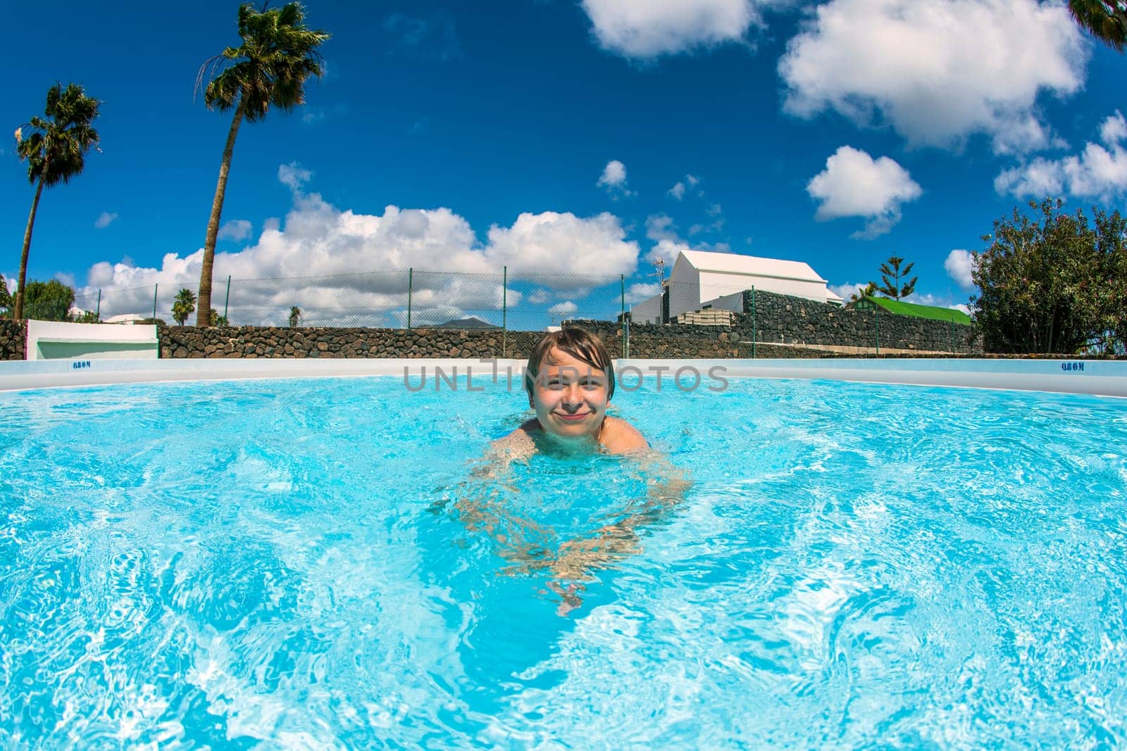 cute boy swimming in the blue pool