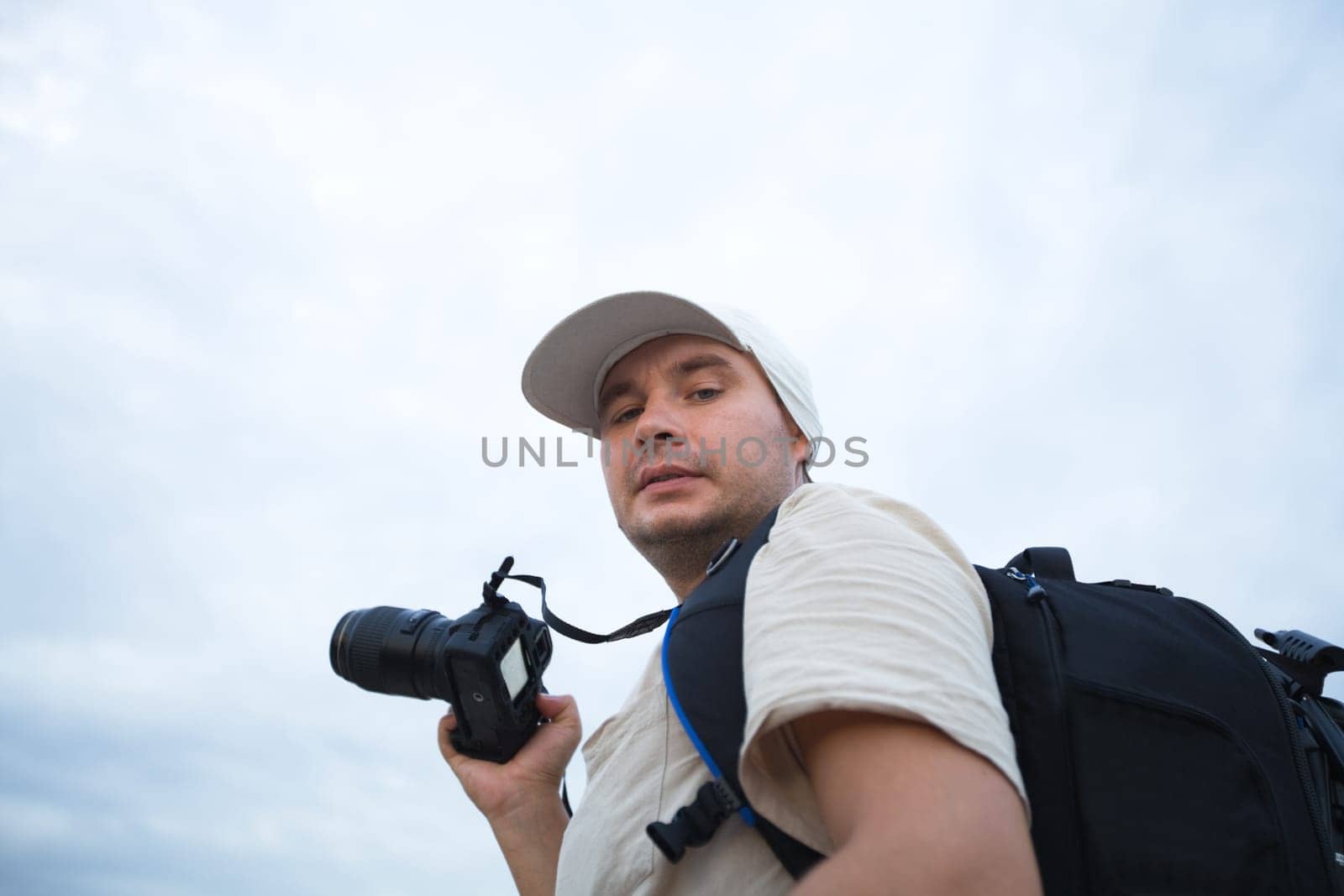 Photographer with digital camera over blue sky background