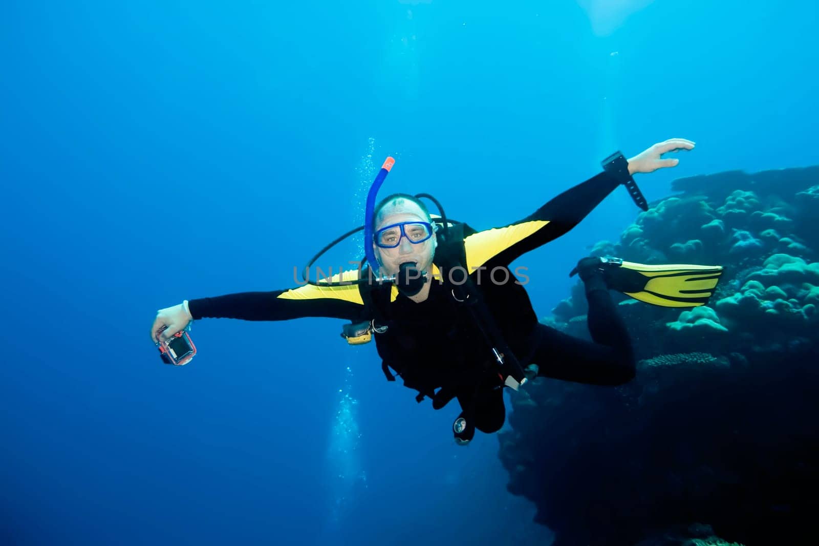 Diver flying underwater with camera.