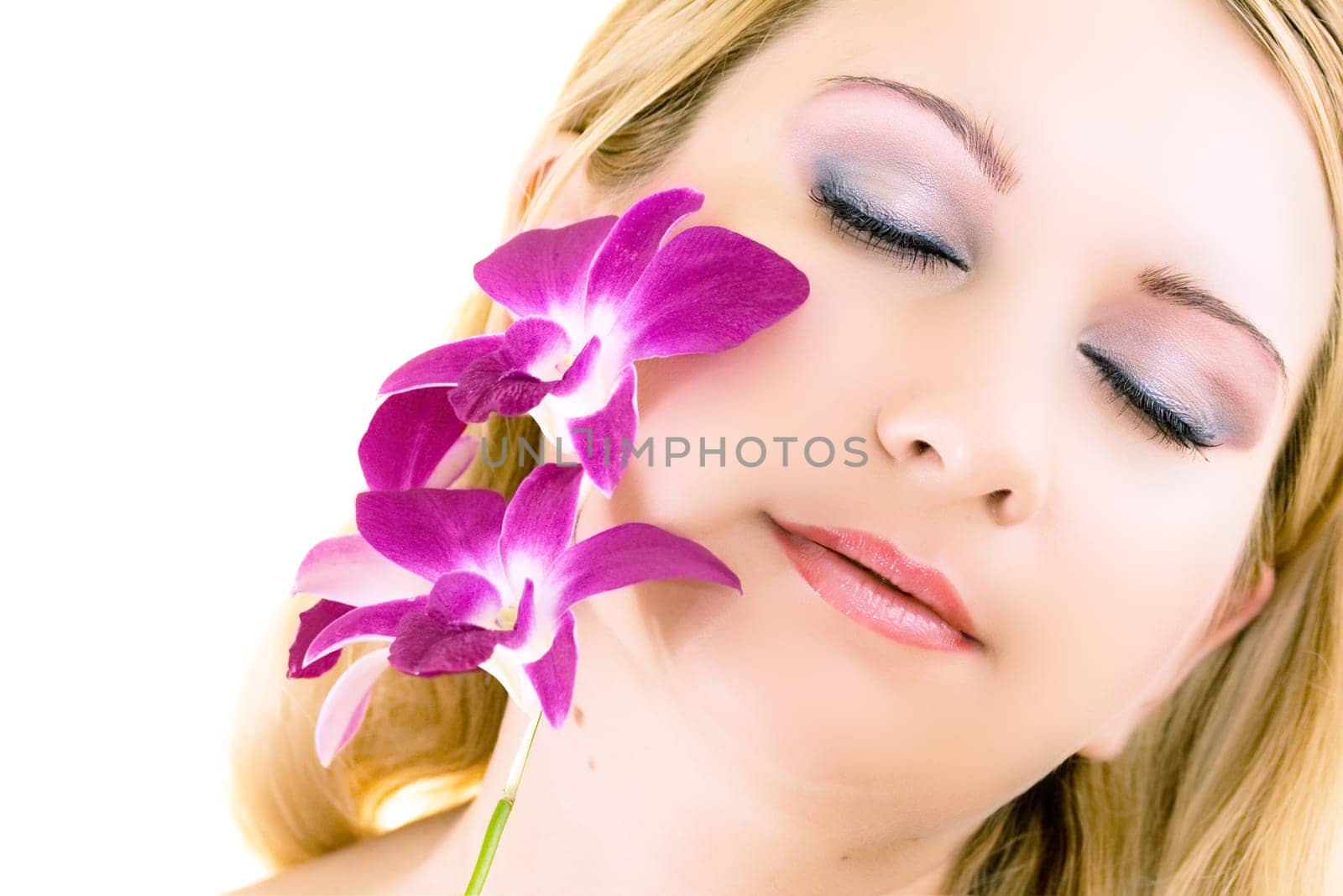 Face of young woman with closed eyes on white background