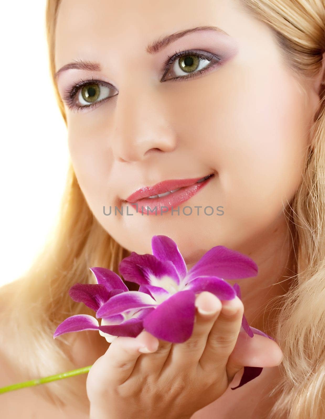 Close-up face of young woman with orchid on white background