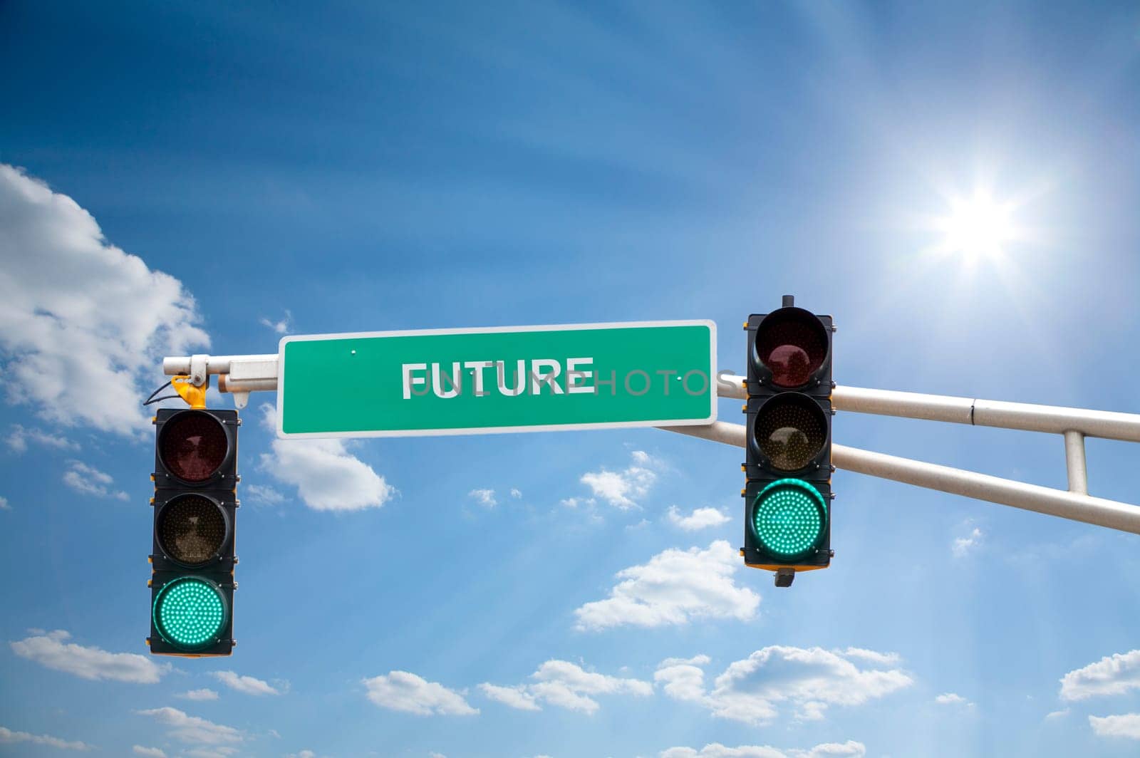 Image of a street sign and traffic lights with blue sunny skies in the background