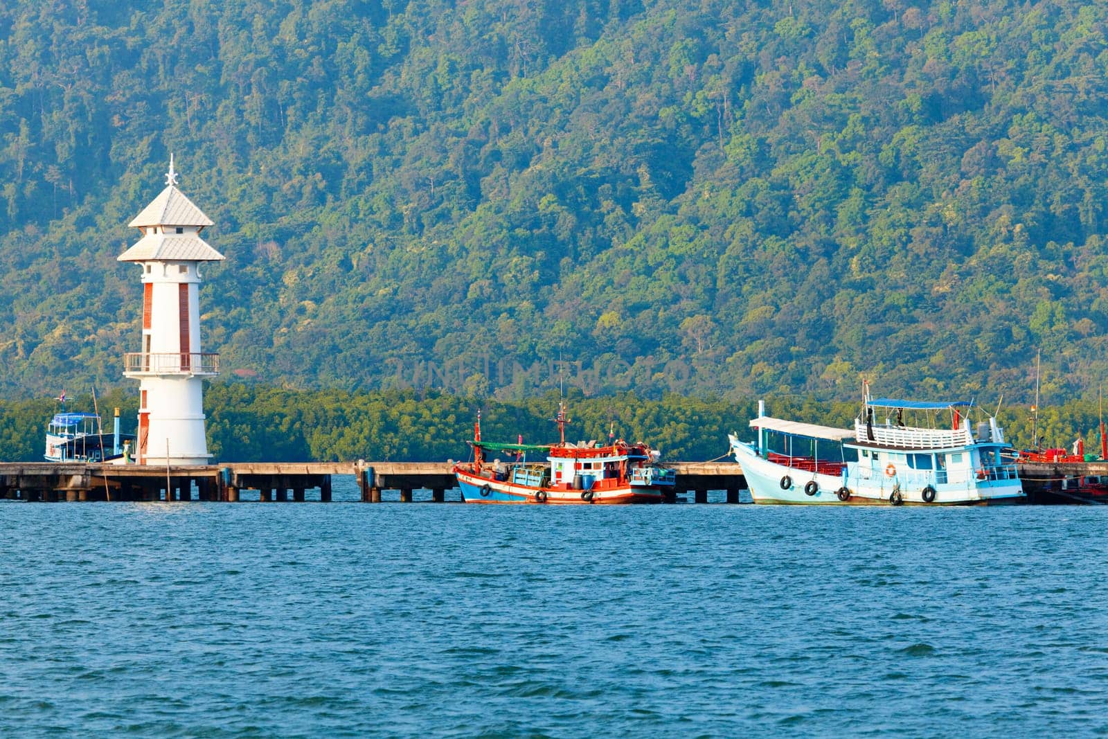 Lighthouse on a pier by a village on Koh Chang Island in Thailand