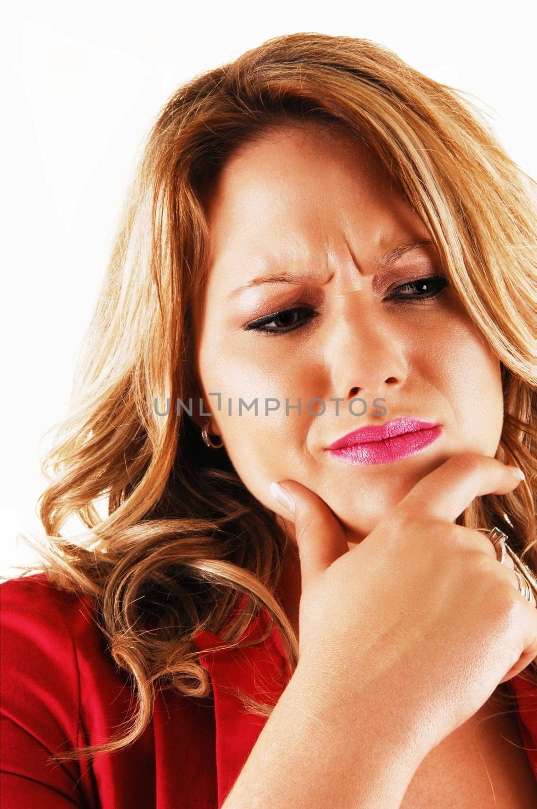 A young blond woman holding her chin with one hand and looking very serious about a problem in closeup over white.