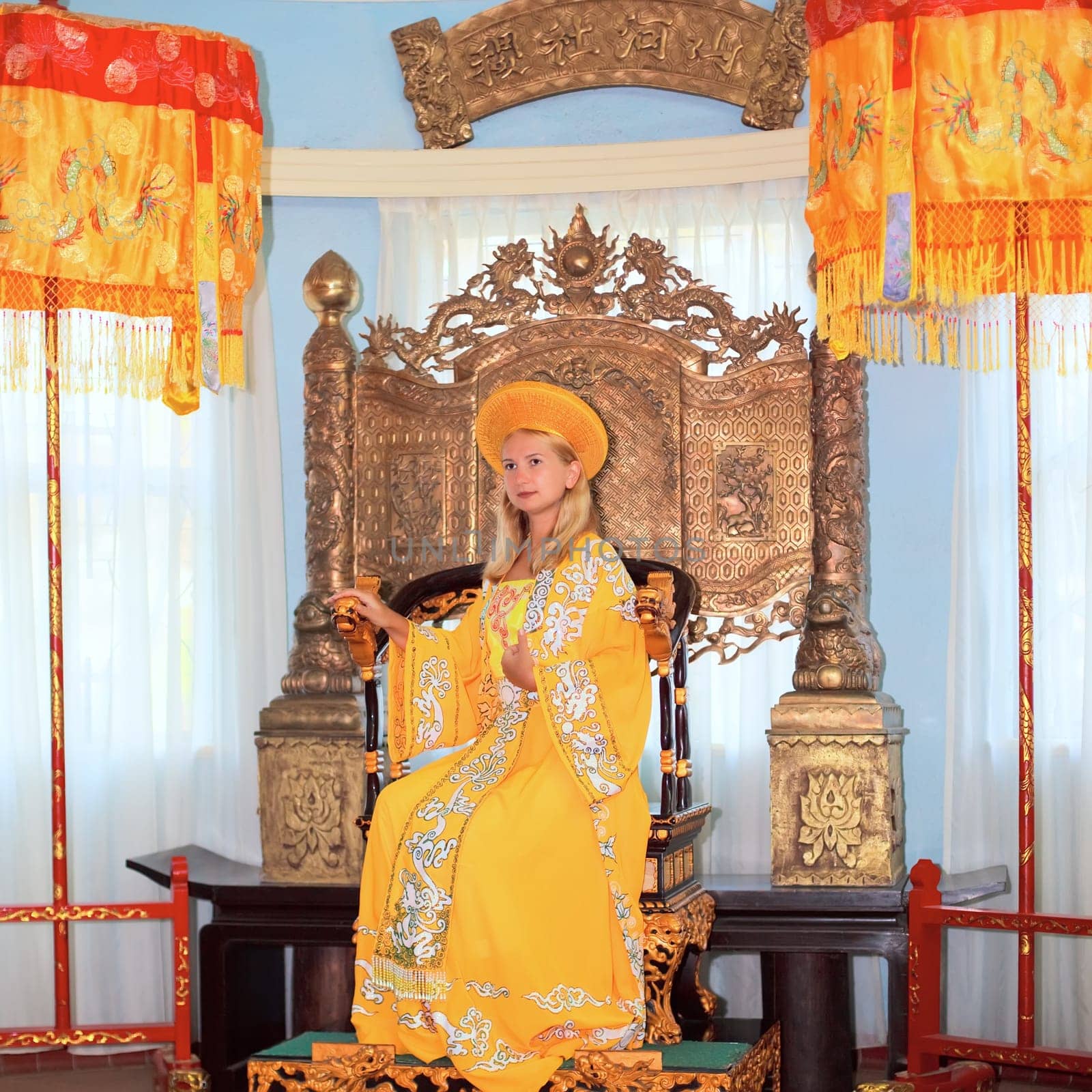Woman in tradicional asiasn clothes sitting in chair