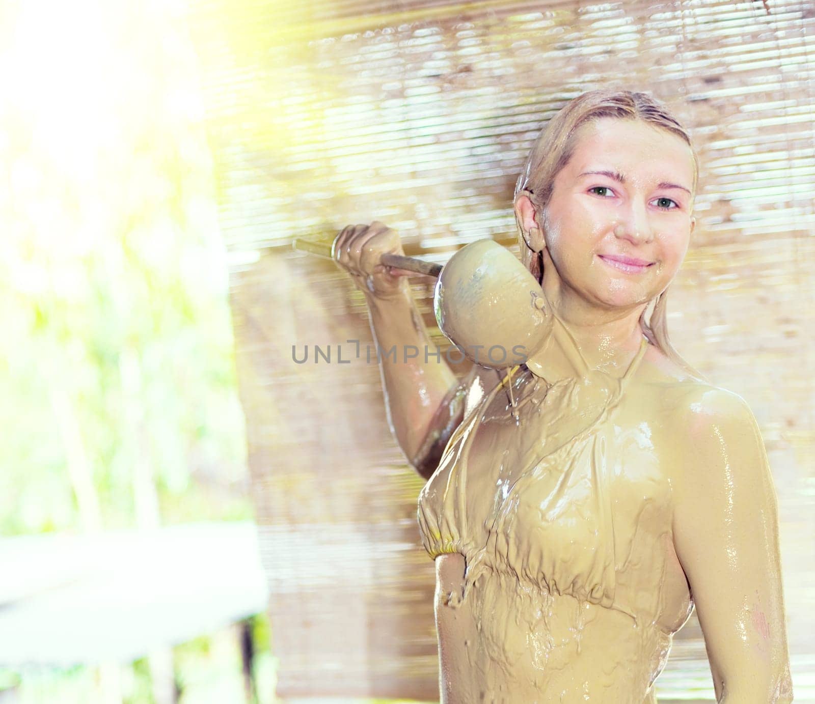 Young woman mudbathing outdoor.
