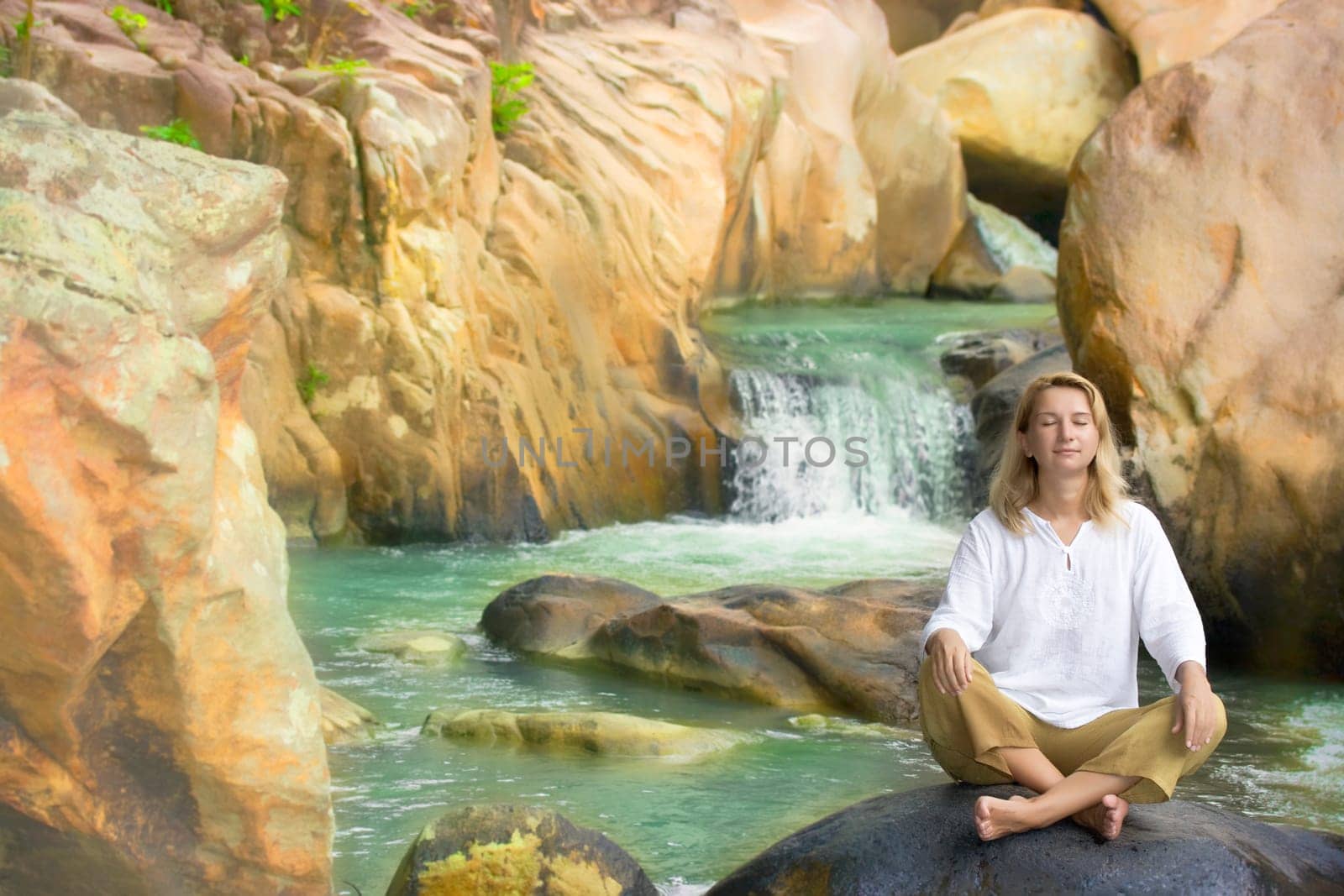 Young woman relaxing on waterfall background