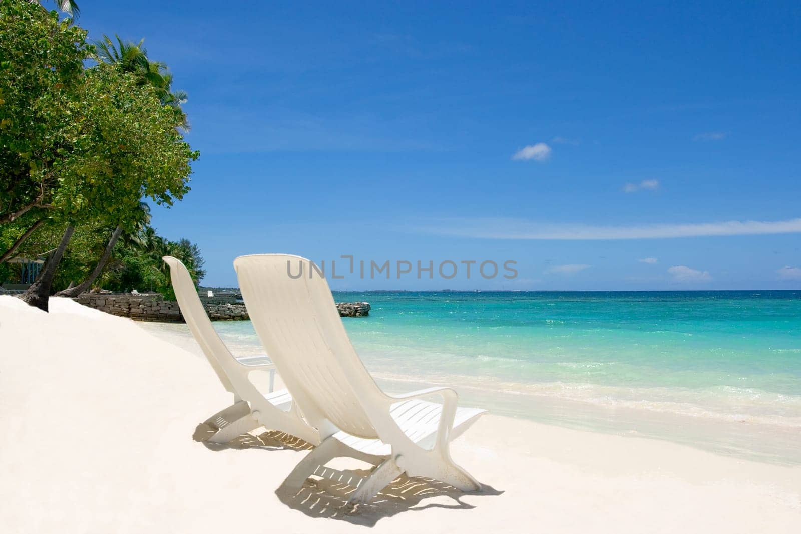 Two empty beach chairs. Coast of Indian ocean. Maldives