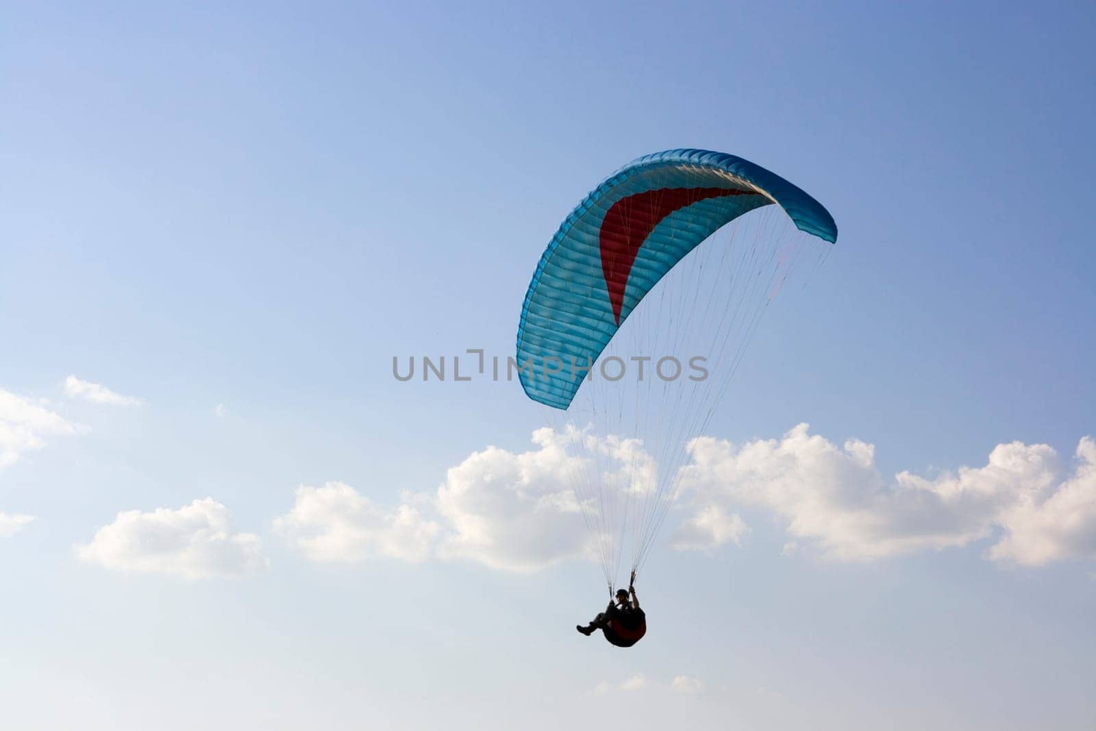 Paraglider with cian wing in the sky
