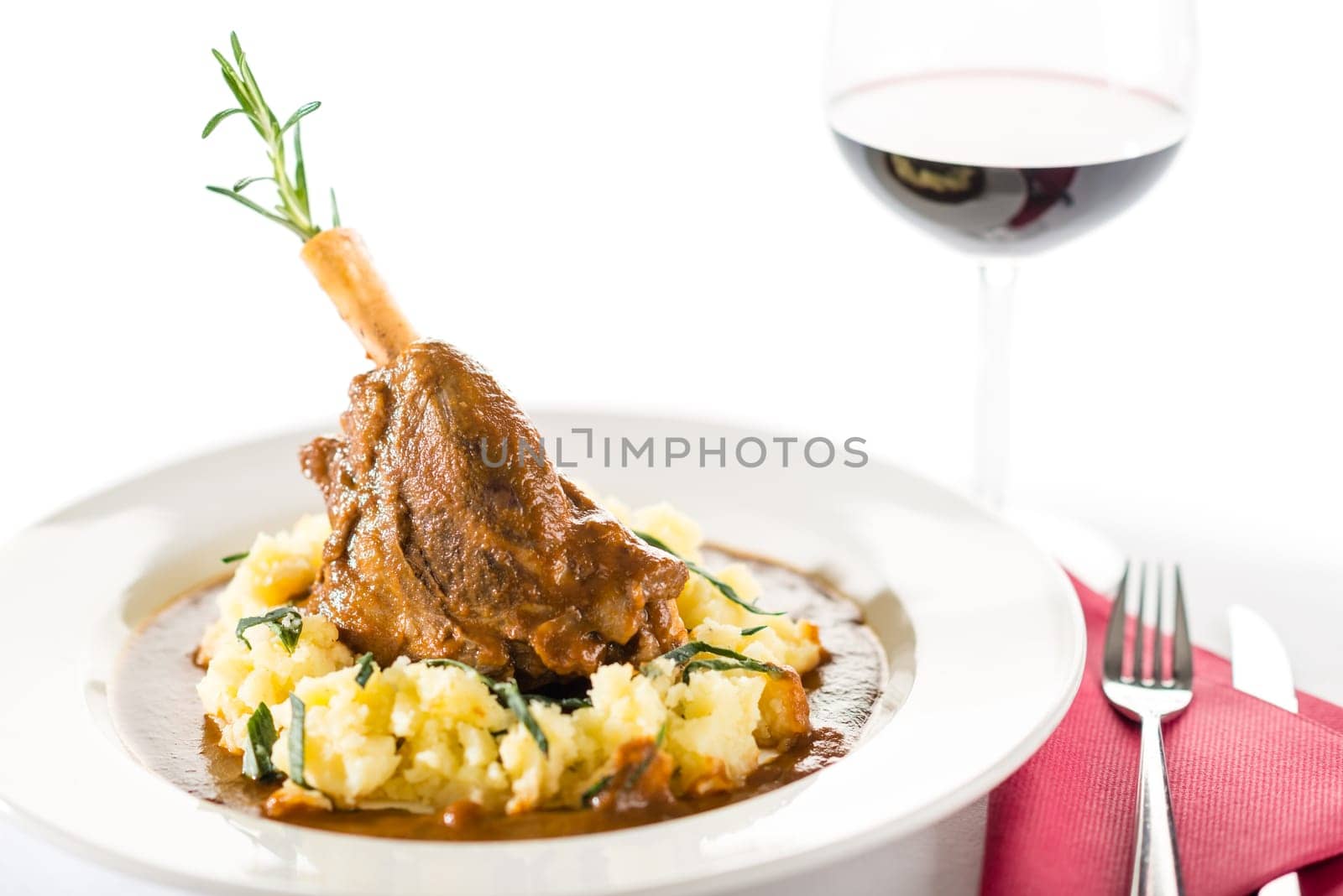 Lamb knee in sauce with mashed potatoes on white background