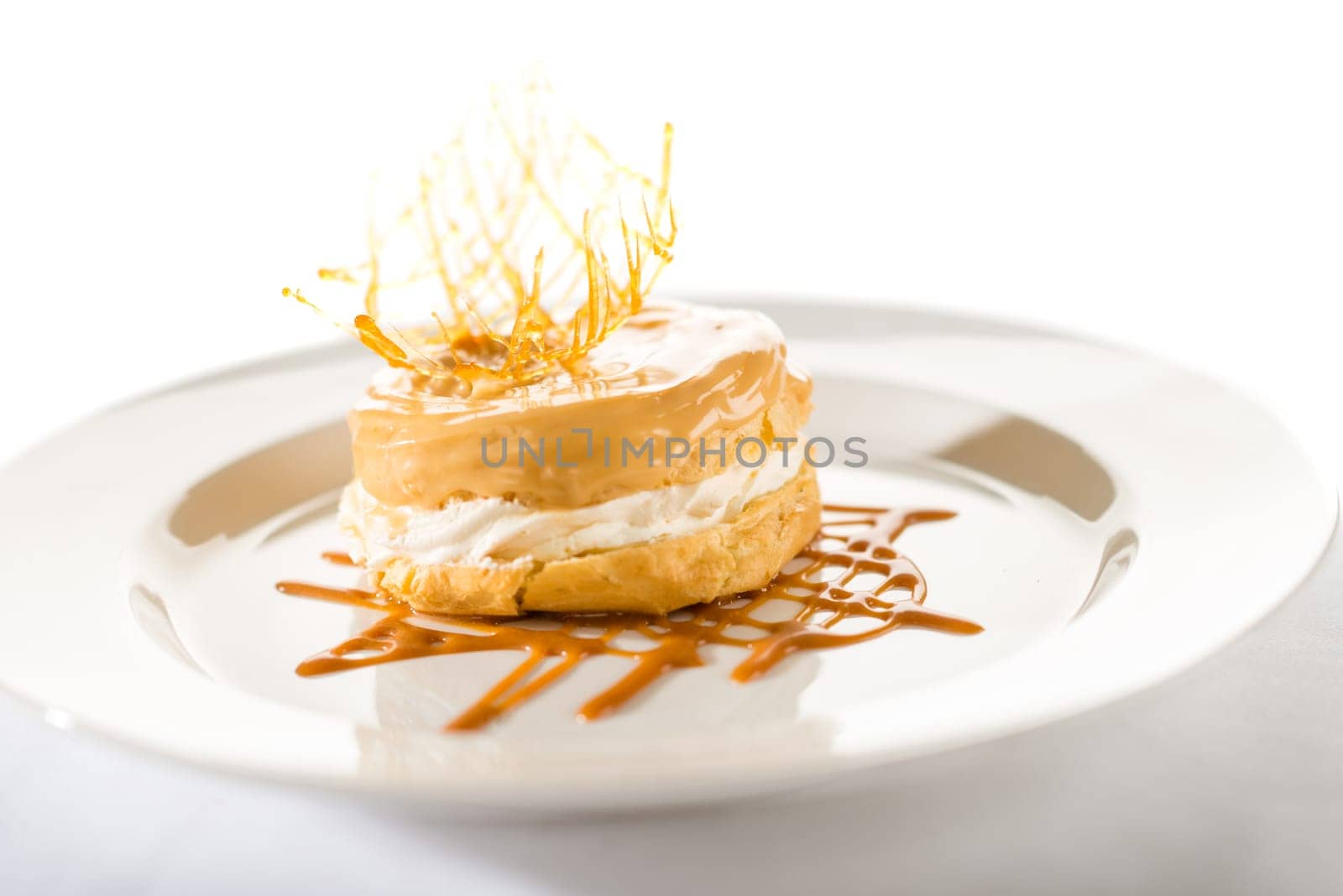 Delicious creamy dessert with caramel topping on isolated background