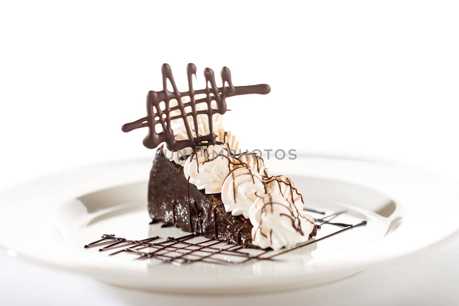 Sacher cake with whipped cream and chocolate isolated on white