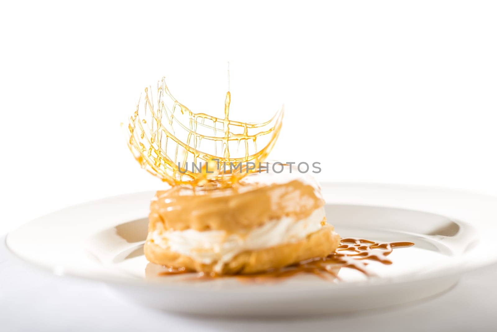 Delicious creamy dessert with caramel topping on isolated background