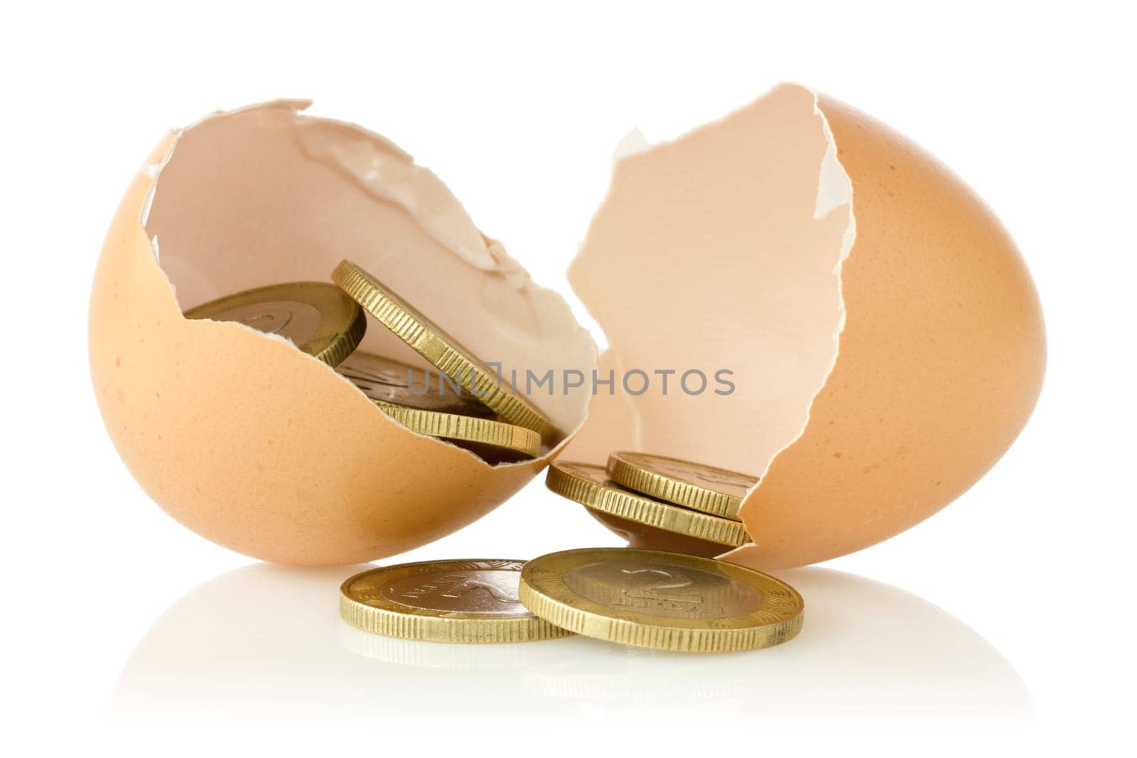 Broken  eggs with coins on white background