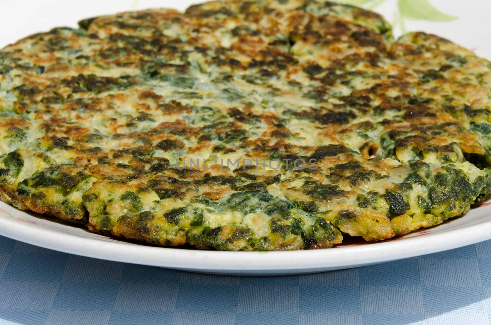 vegetable frittata just baked on white plate