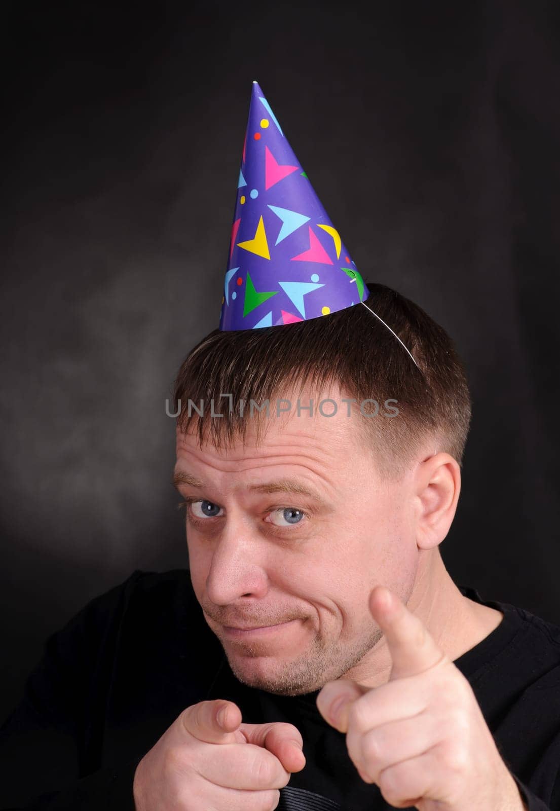 happy man in the festive hood on the dark background