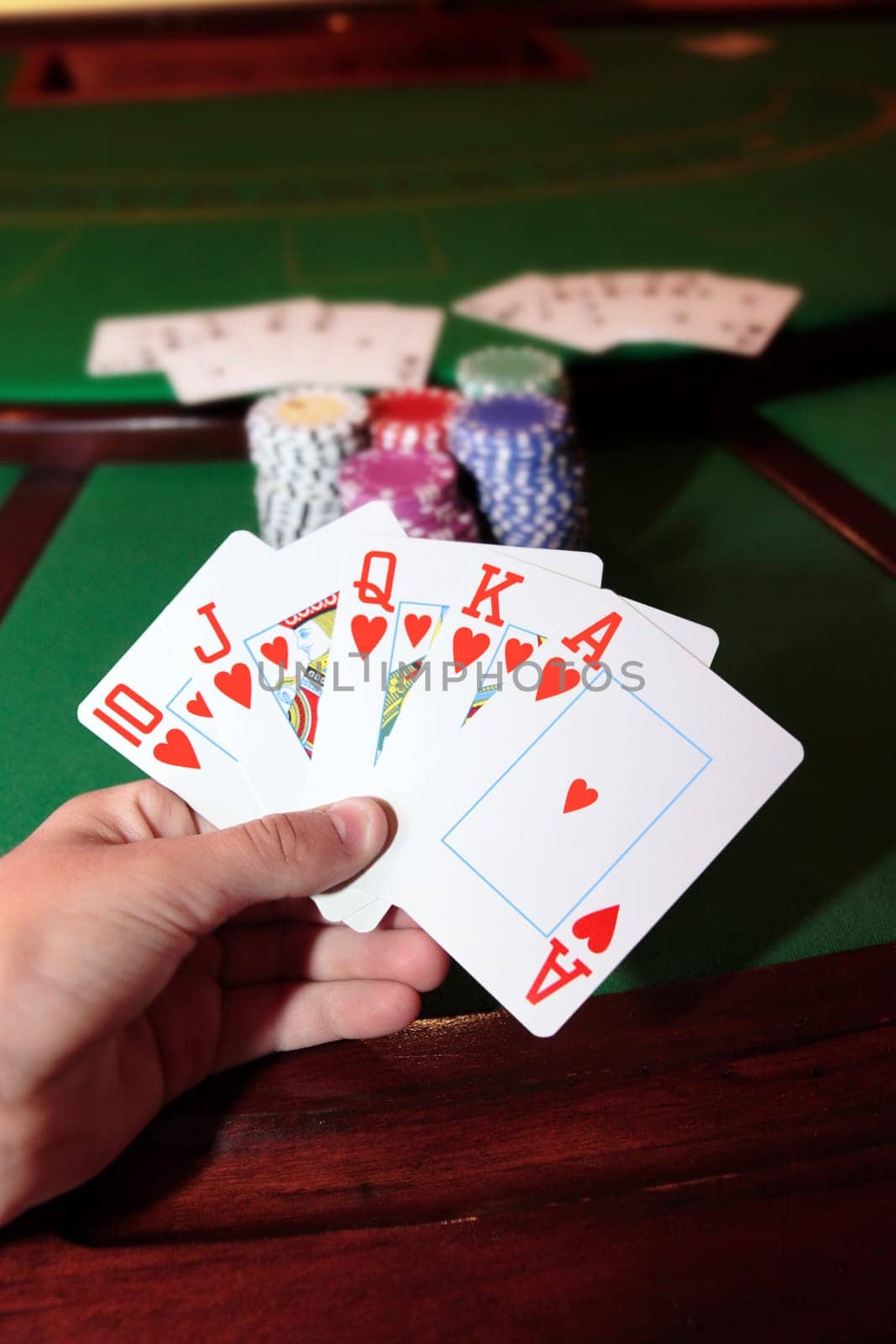 green casino table with a hand of a royal flush in a poker game