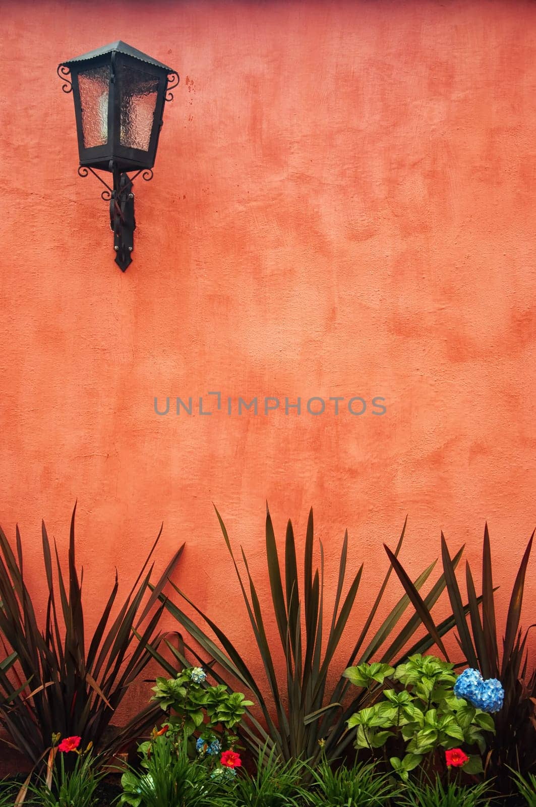A red colonial wall with a lantern in the upper left.