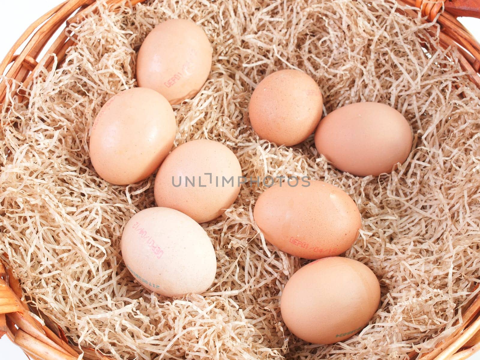 Eggs in a wicker basket with straw