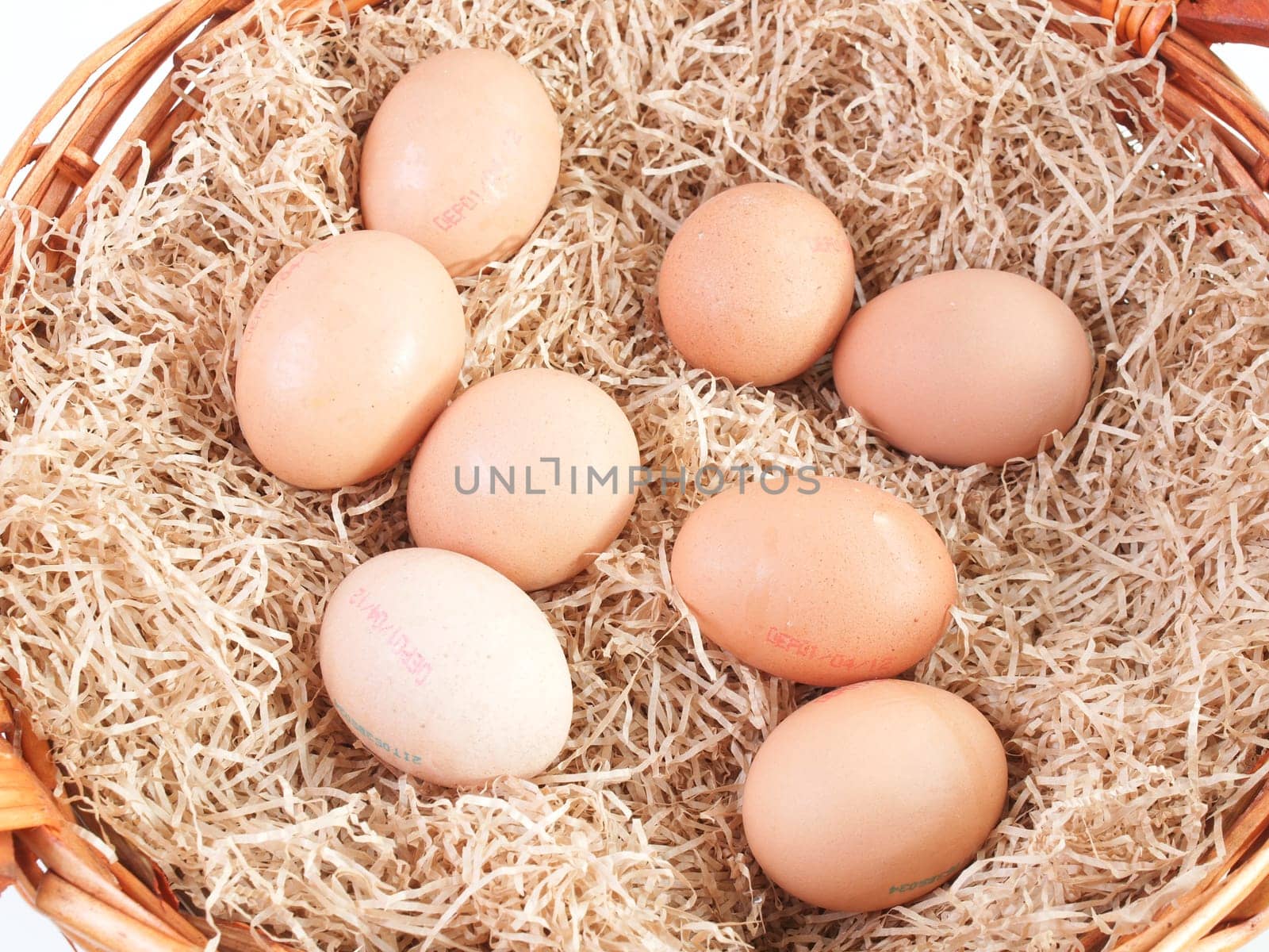 Eggs in a wicker basket with straw