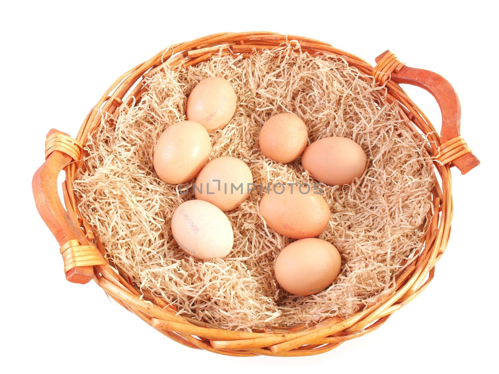 Eggs in a wicker basket with straw - isolated over white