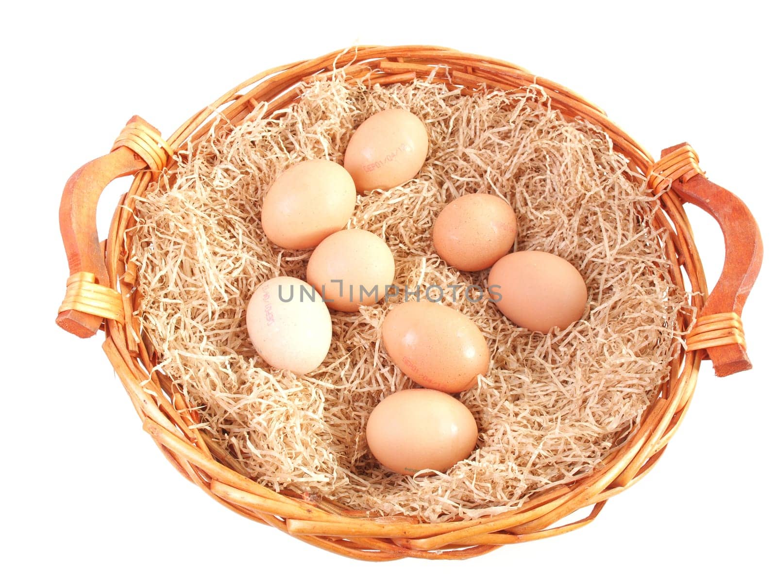 Eggs in a wicker basket with straw - isolated over white