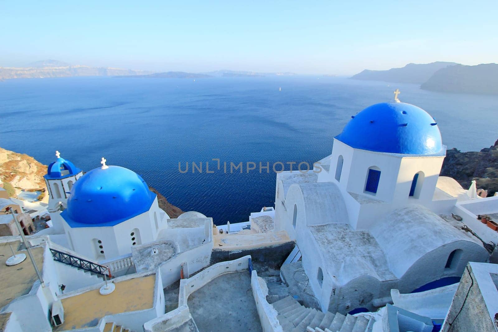 Famous Blue Domes of orthodox churches on the sea background in Santorini island, Greece.