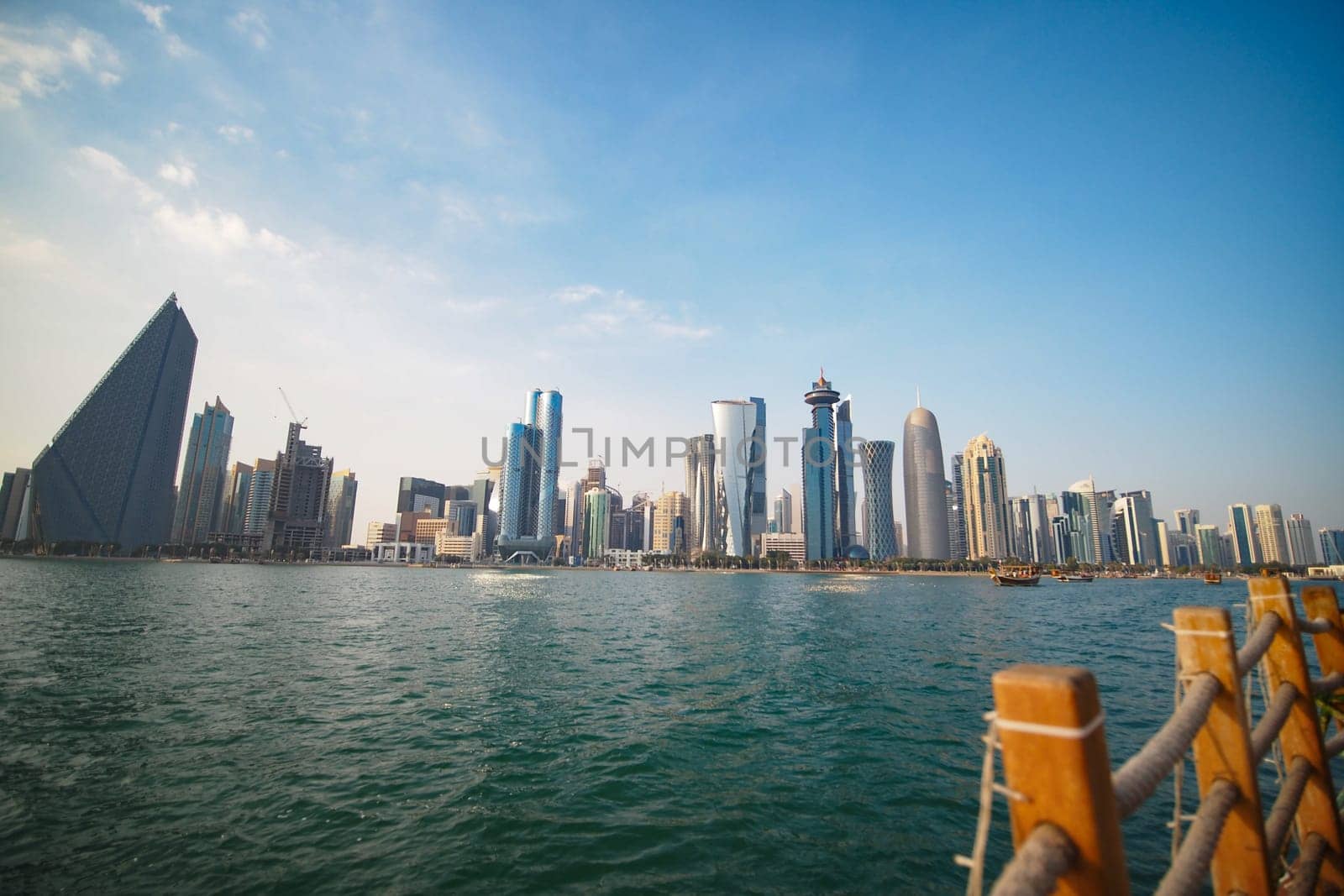 Modern skyscrapers line the waterfront under a clear blue sky.