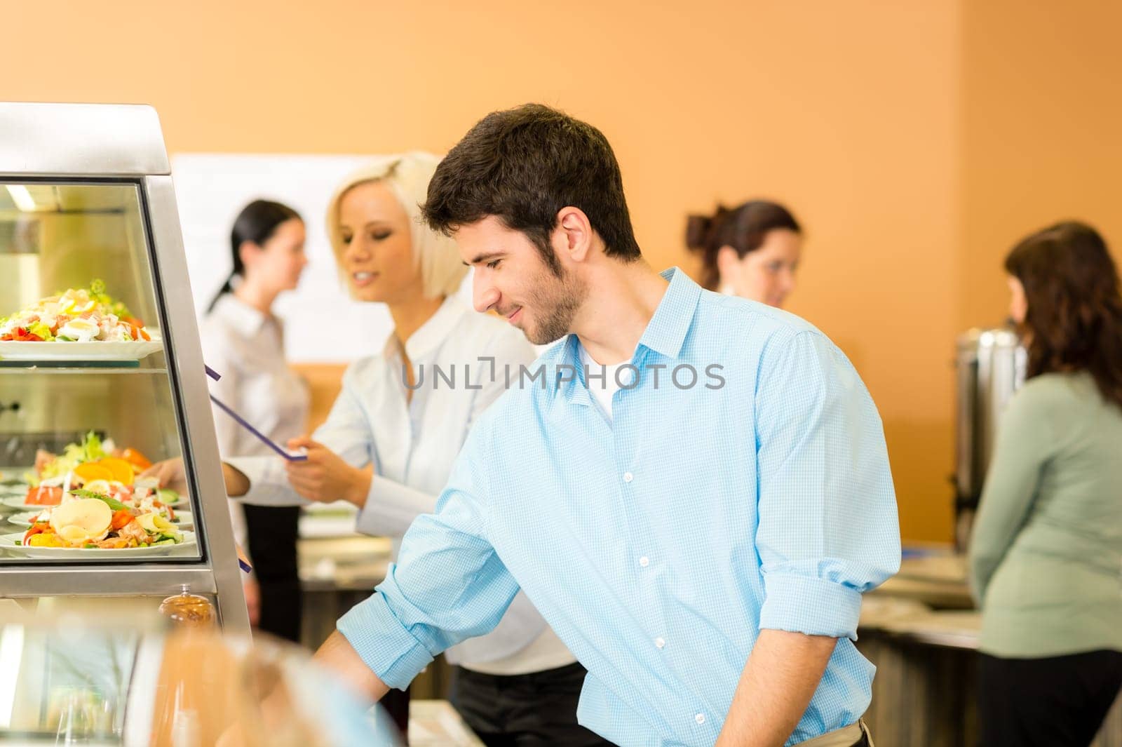 Business man take cafeteria lunch food from display cabinet self-service