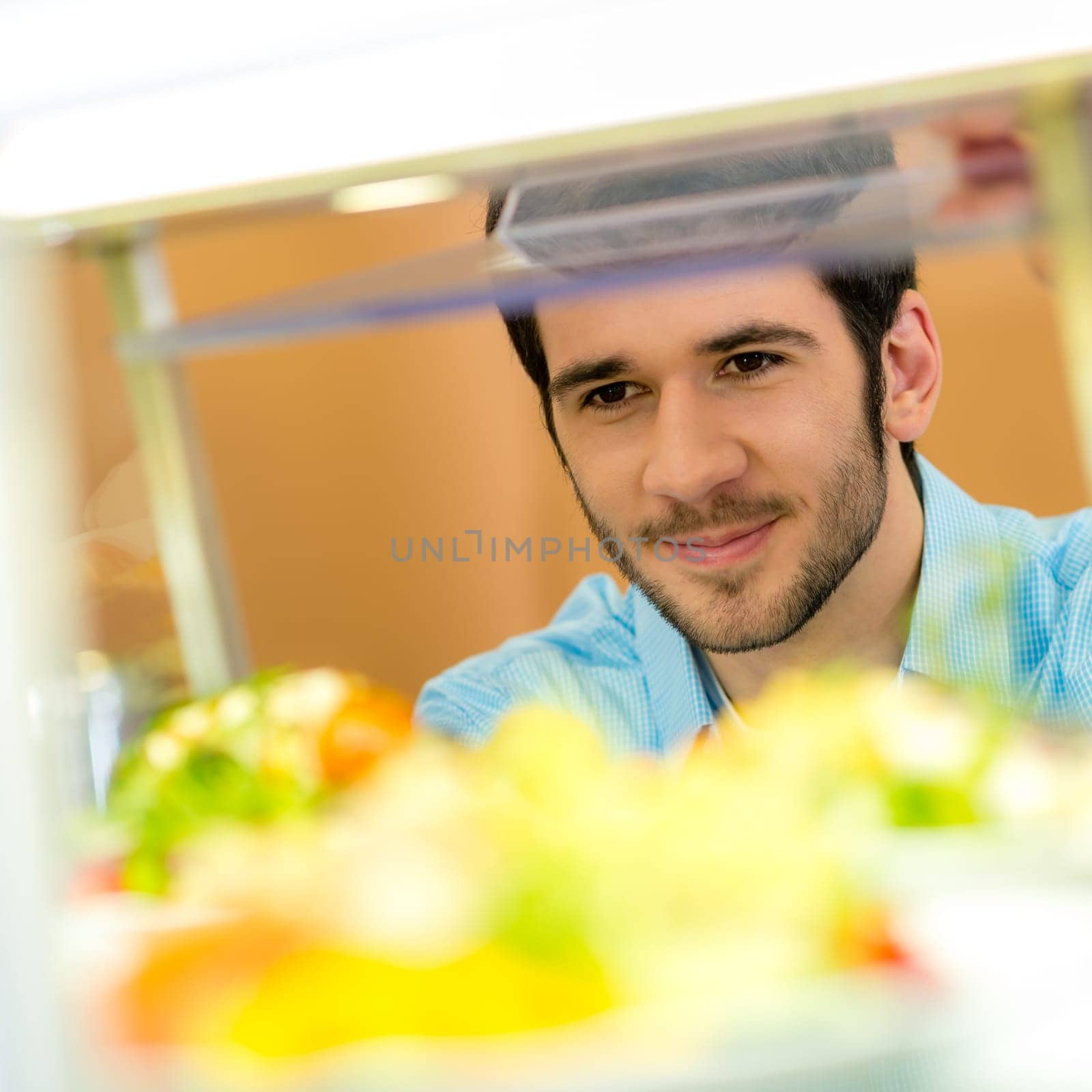 Cafeteria food display cabinet young man choose salad healthy lifestyle