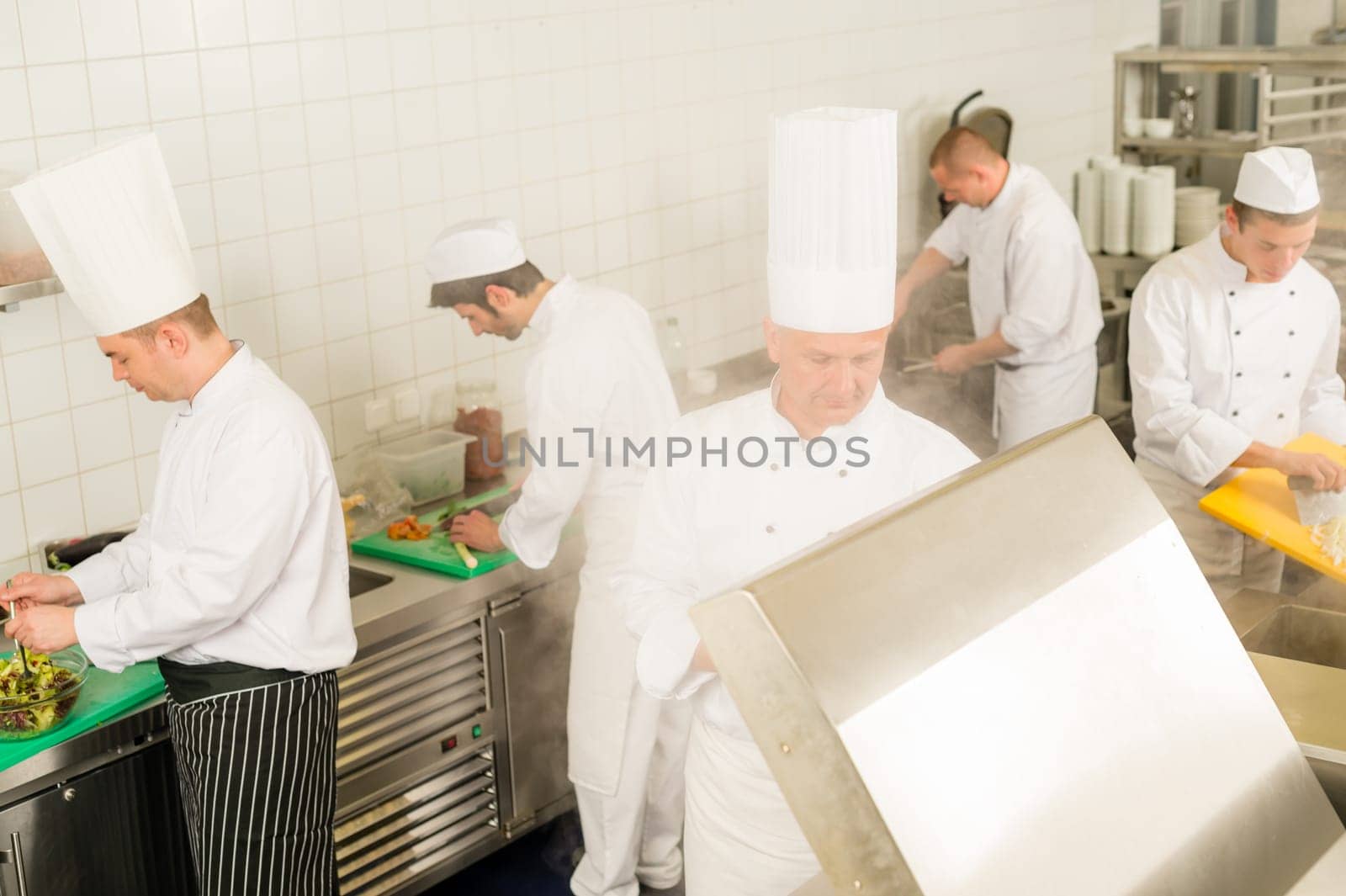 Professional kitchen busy team cooks and chef prepare meal
