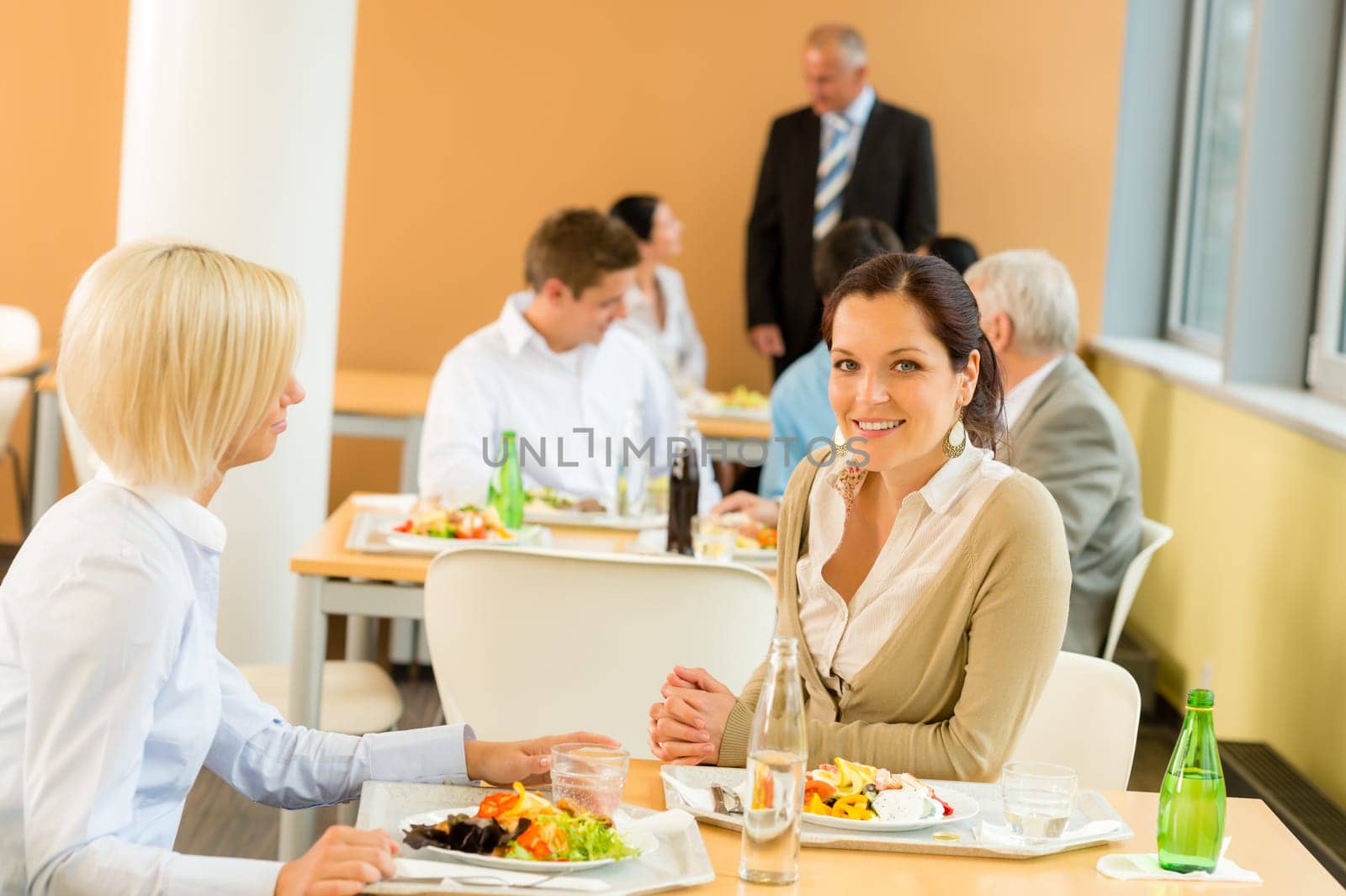 Cafeteria lunch young business women eat salad at office canteen