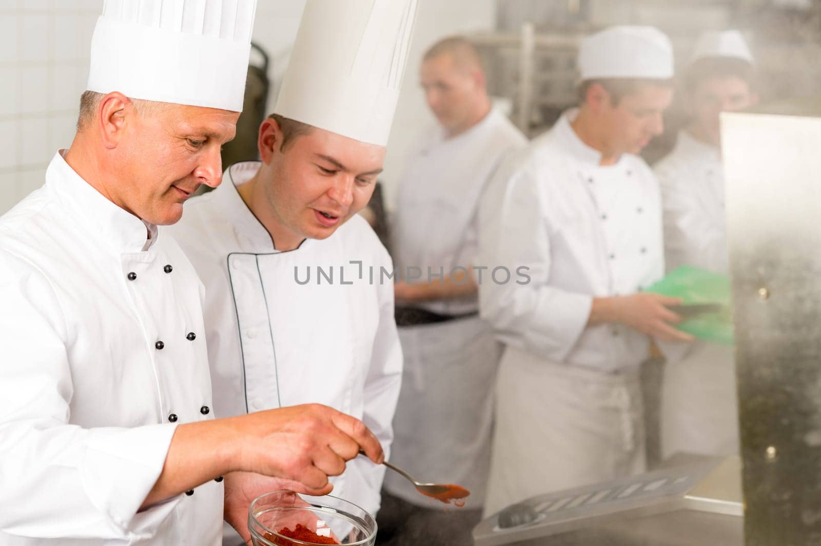 Professional kitchen chef cook add spice paprika prepare food meals