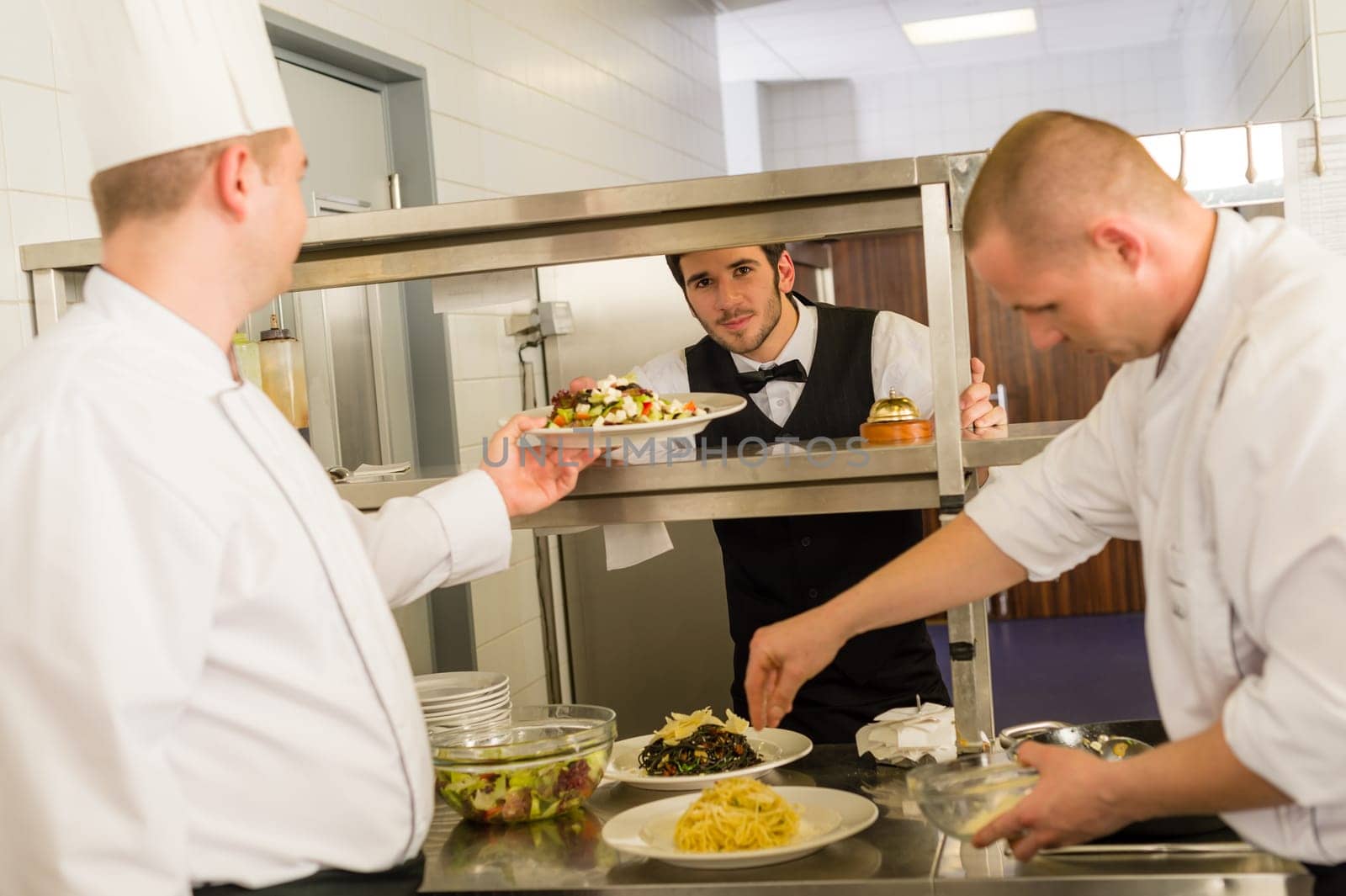 Professional kitchen cook prepare food service give meals to waiter
