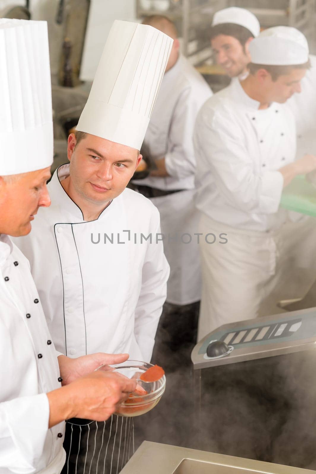 Professional kitchen chef cook add spice paprika prepare food meals
