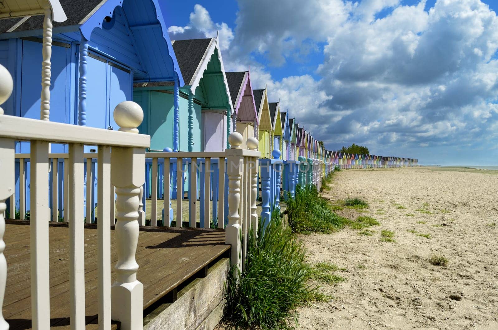 A line of brightly colored beach huts by the ocean