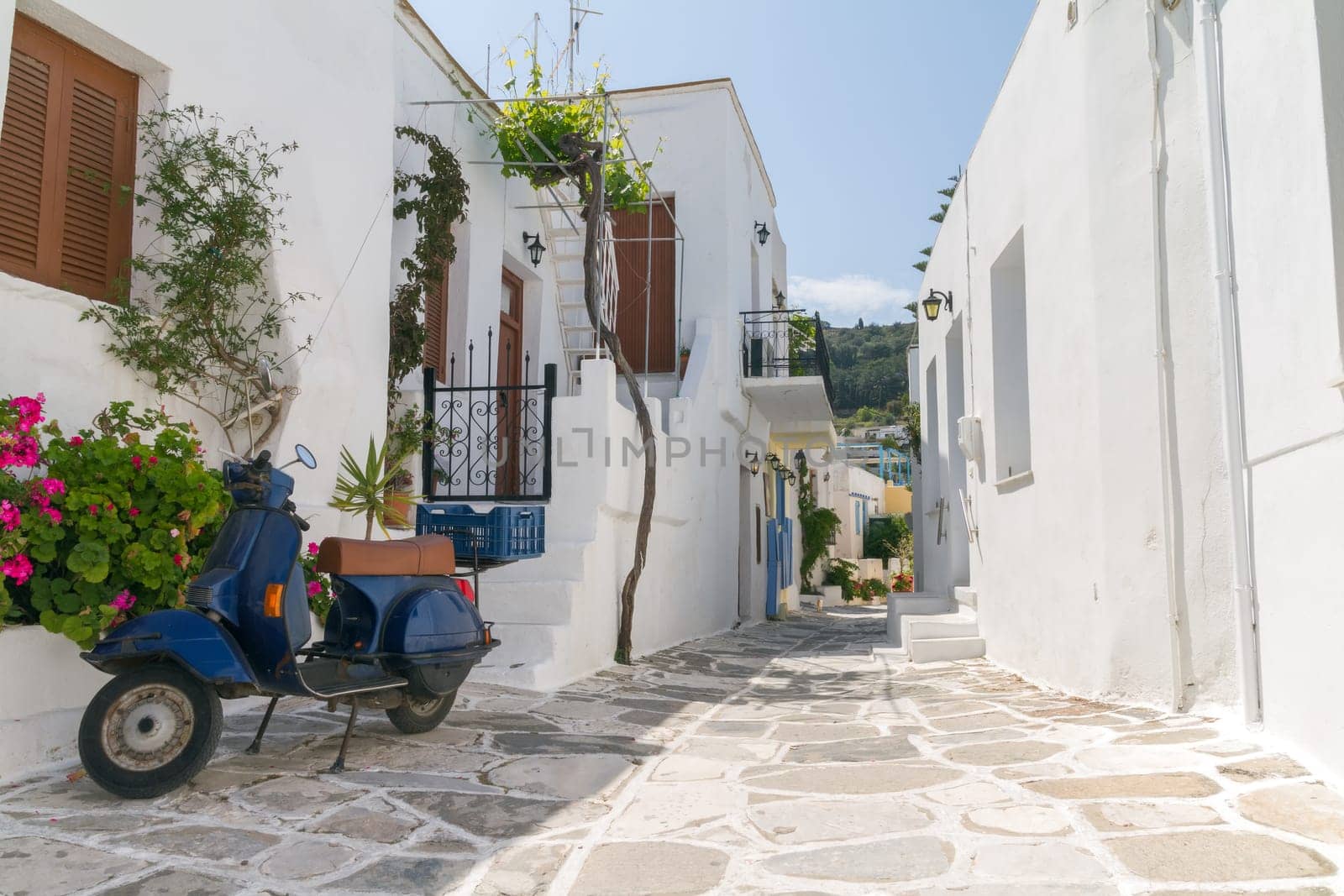 Classical narrow street with a painted sidewalk in Parikia