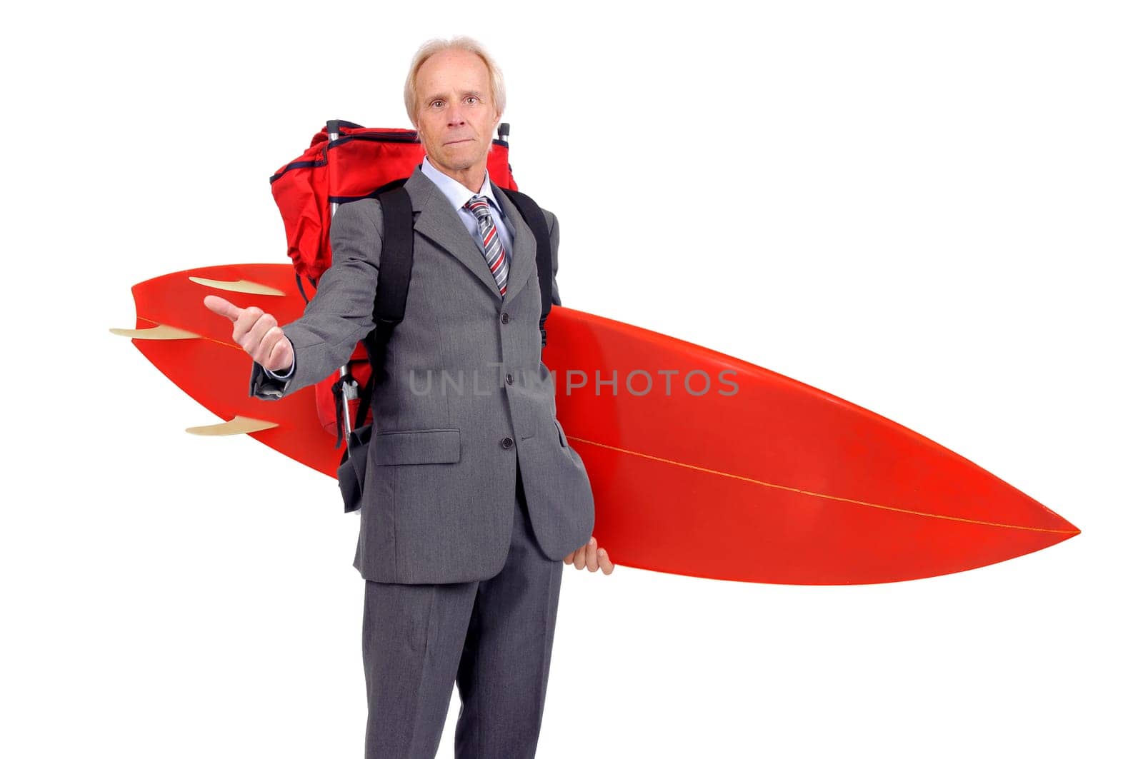 Mature businessman hitchhiking with backpack and surf board