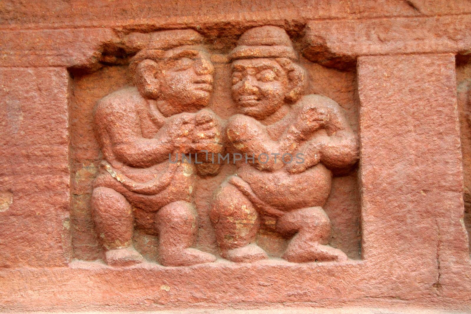 Stone carving of dwarfs on the base wall of cave temple at Badami in Karnataka, India, Asia
